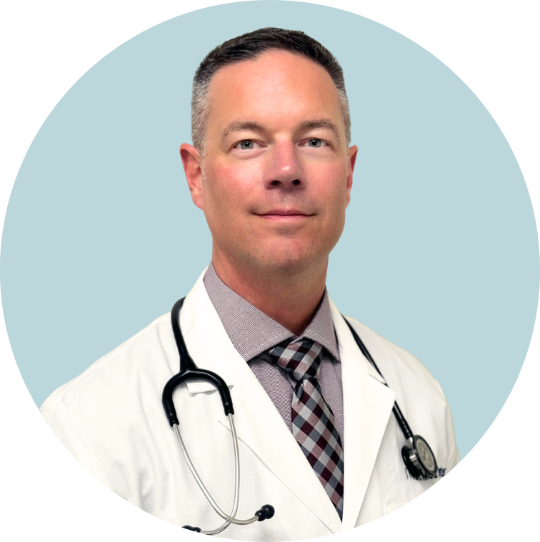 A male doctor wearing a white coat and a stethoscope around his neck, standing against a light blue background.