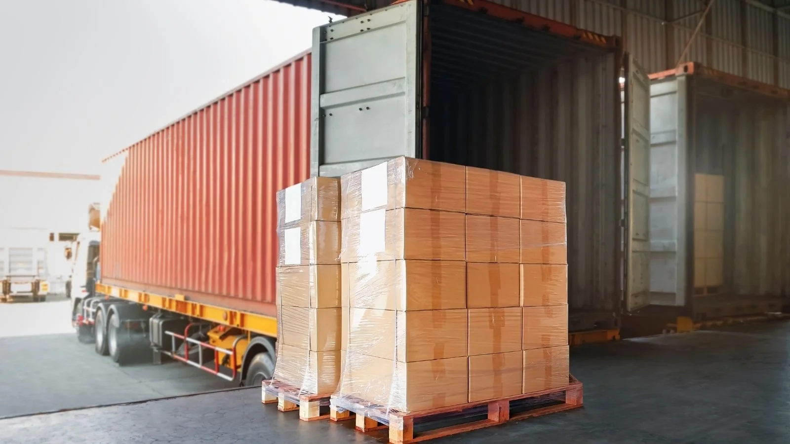Pallet of imported goods unloaded from a shipping container at a UK bonded warehouse loading bay