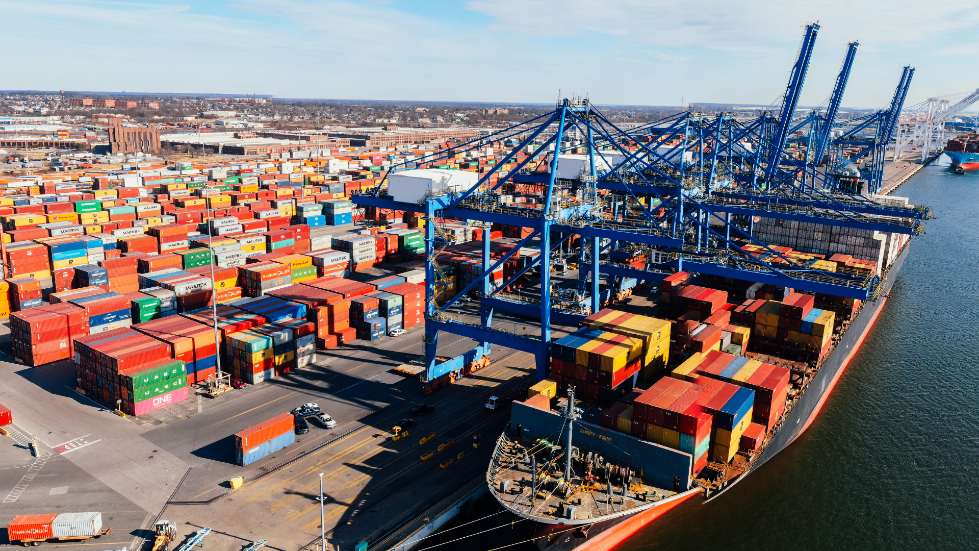 Container ship being loaded at port, representing ongoing customs compliance management for UK importers and exporters