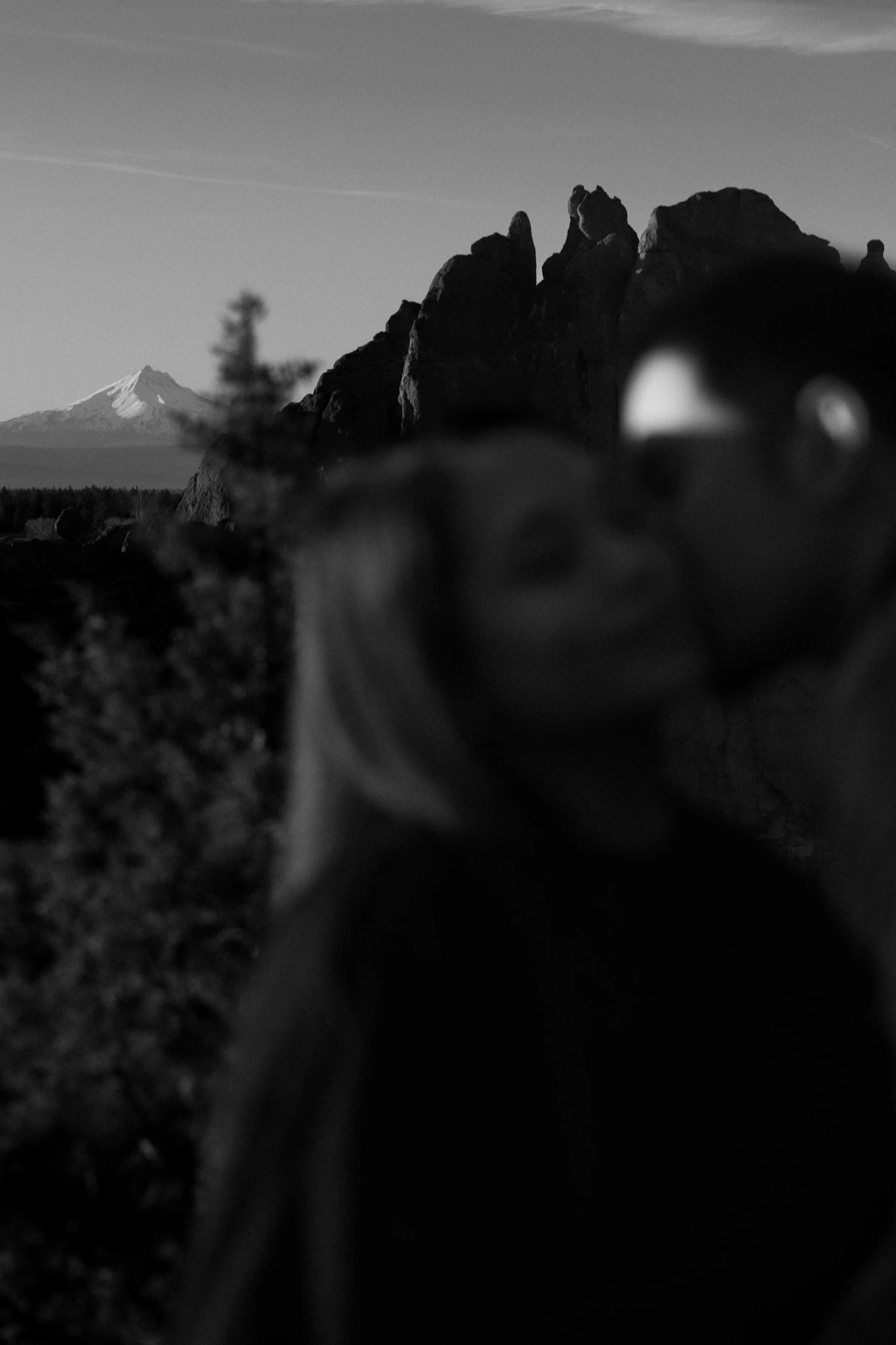 man and woman in Smith Rock State Park in central oregon kissing with mt. jefferson in the back