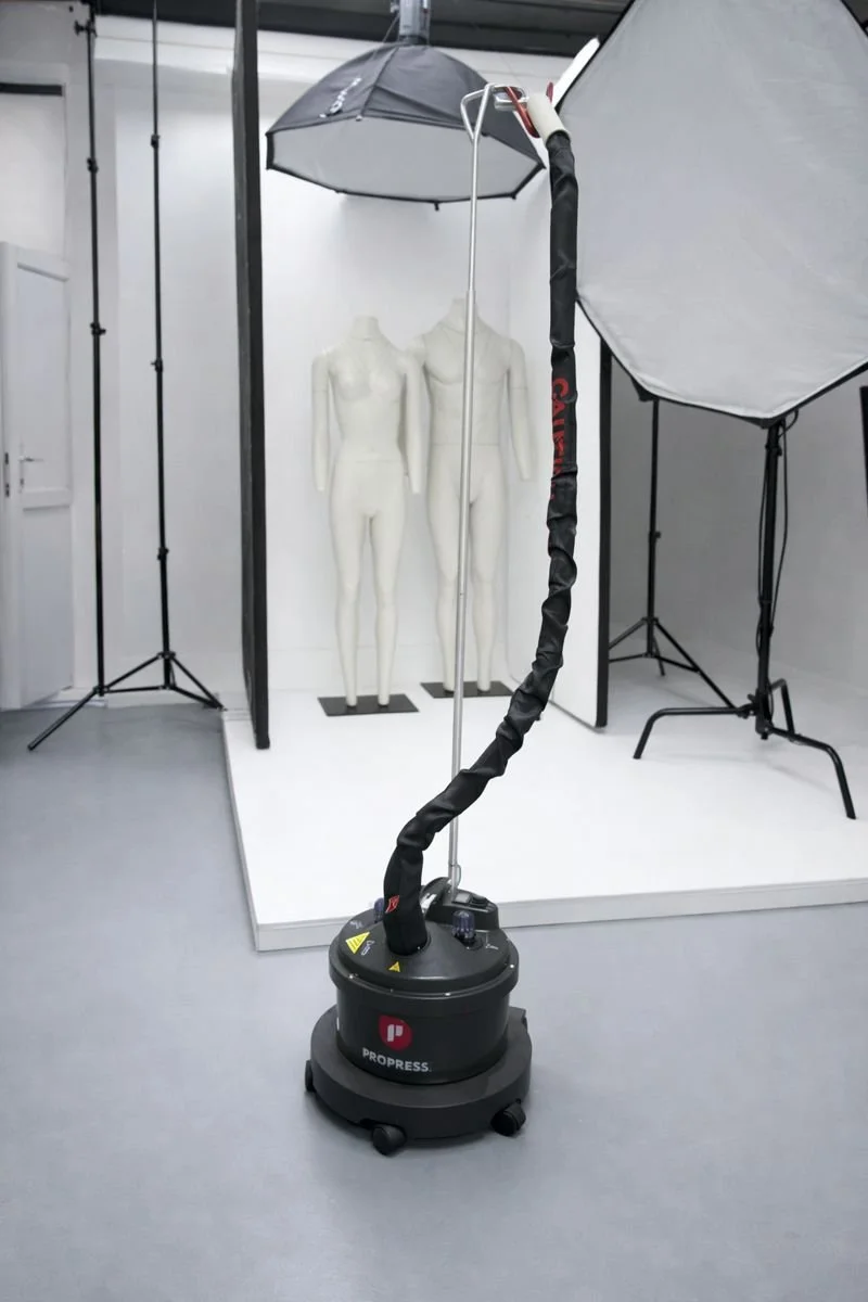 Photography studio setup with lighting equipment, mannequins, and an ultrasonic cleaning device.