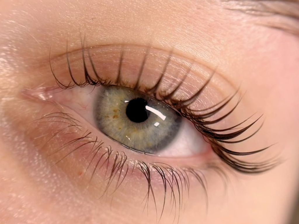 Close-up of a human eye with light-colored iris and long eyelashes.