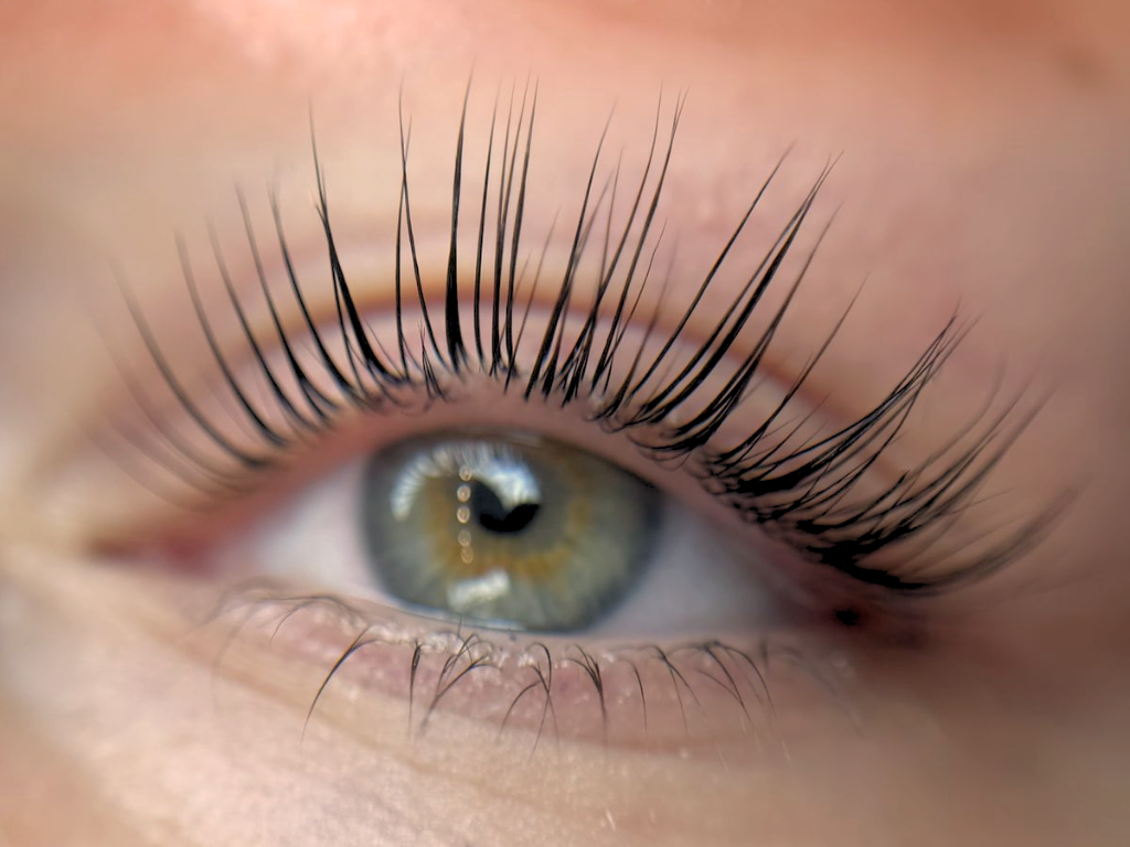 Close-up of a person's eye with long eyelashes and a hazel iris.