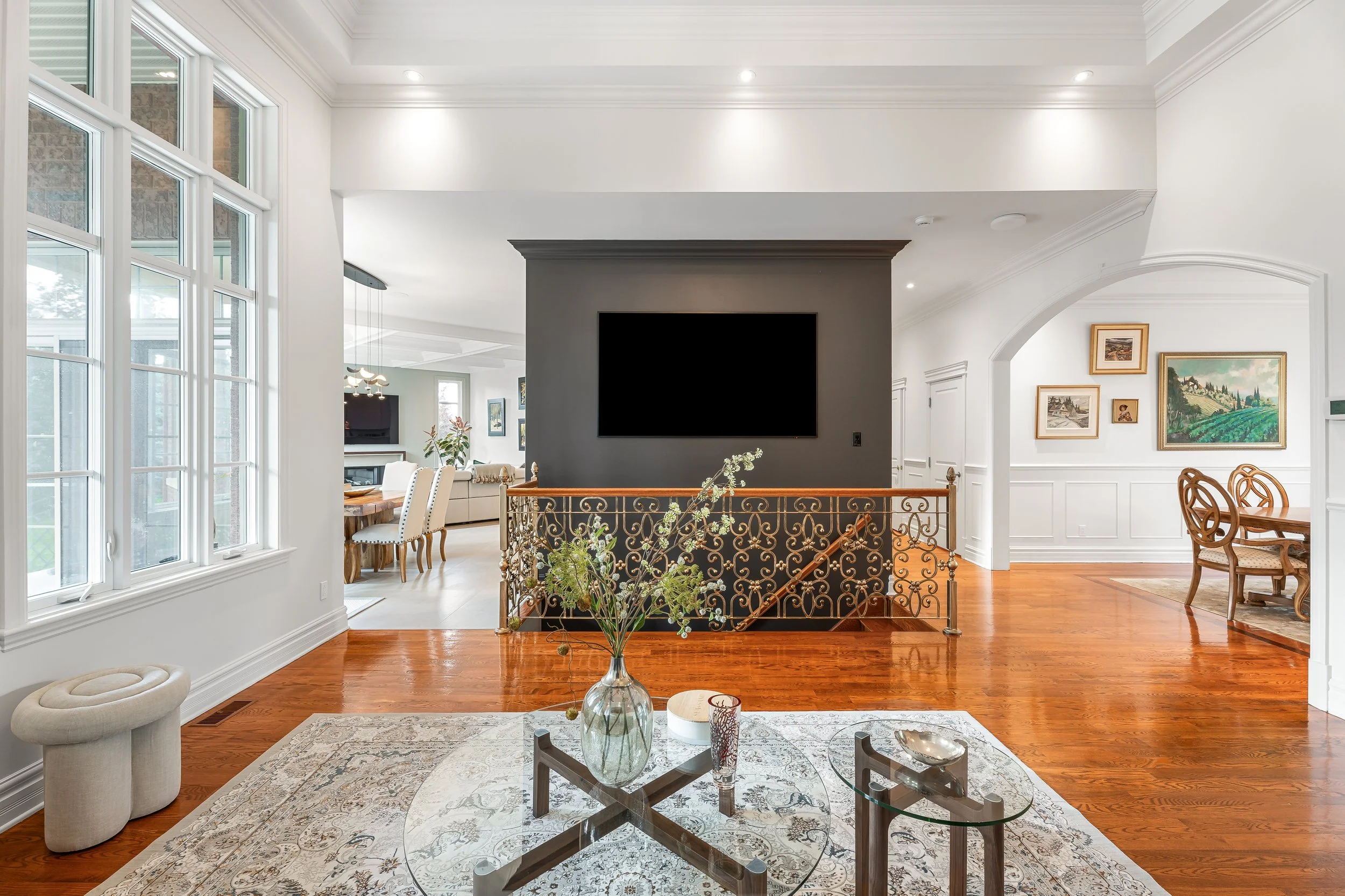 Residential high-end renovation in Brossard near Montreal showcasing a luxurious living room with large window and integrated television. 