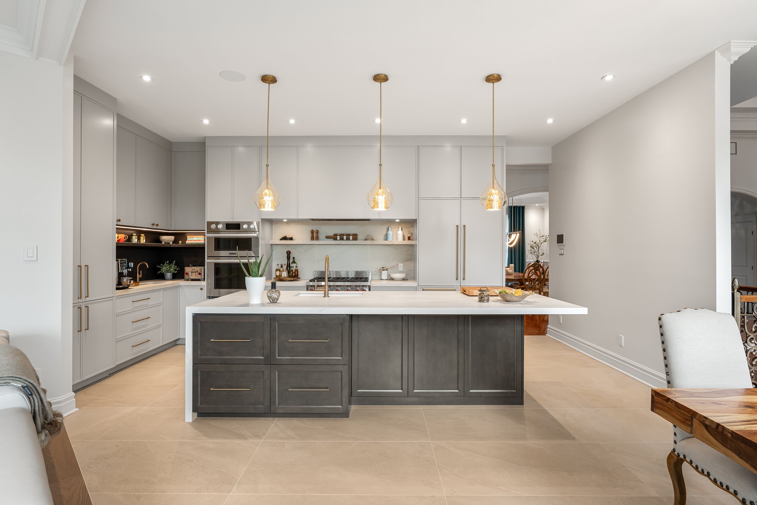 High-end kitchen renovation in Brossard near Montreal featuring custom cabinetry, large island, and integrated lighting.