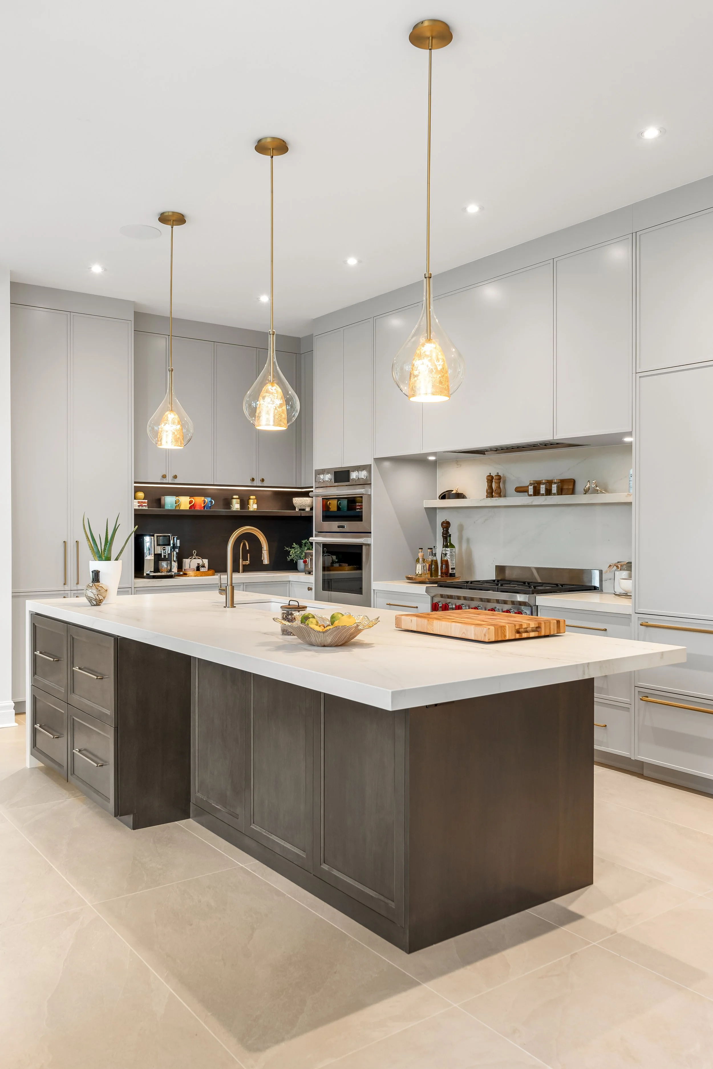 High-end kitchen renovation in Montreal featuring custom cabinetry, Dekton countertops, and pendant lighting.