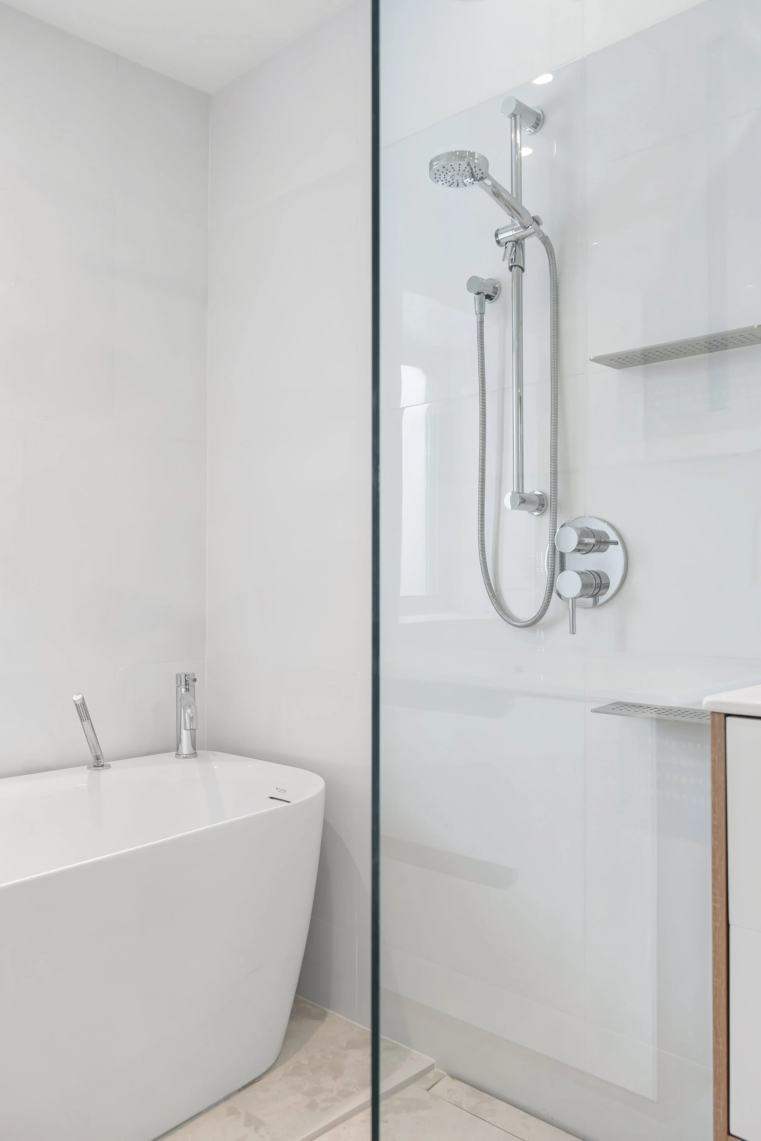 Luxury bathroom renovation in Montreal featuring a freestanding tub in a wet room with integrated shower shelving. 