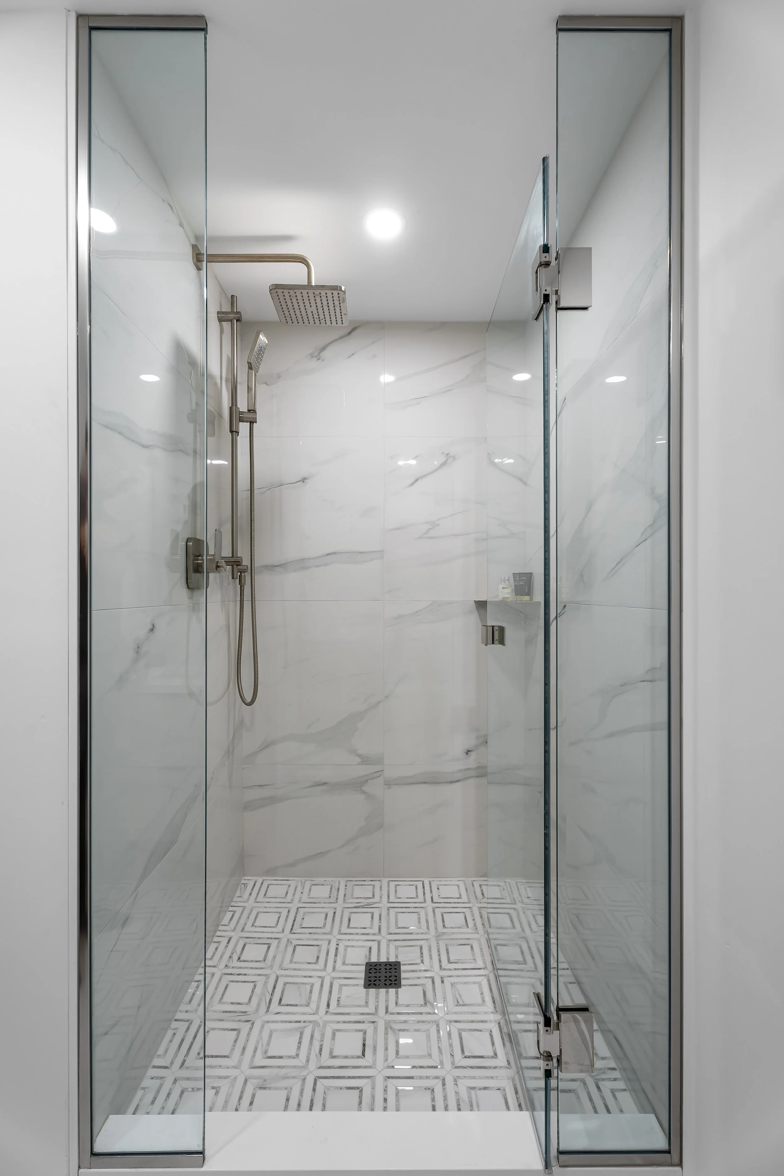 A high-end custom shower in Montreal renovation featuring mosaic tile and glass doors. 