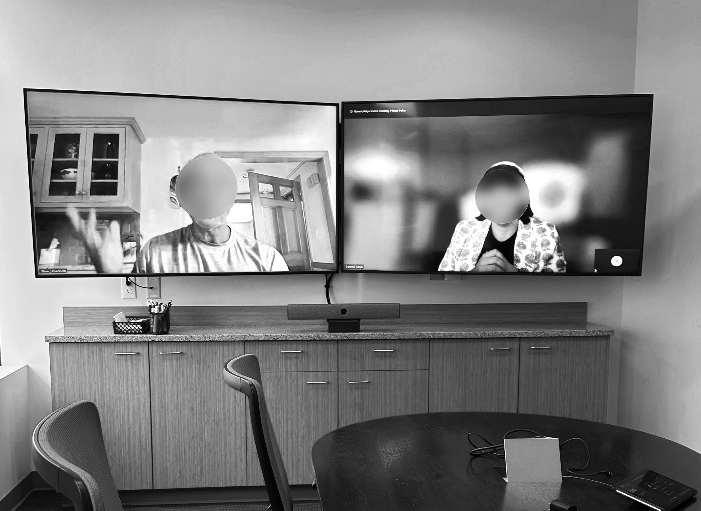 Remote user interview being conducting in an office with a different participant on each screen
