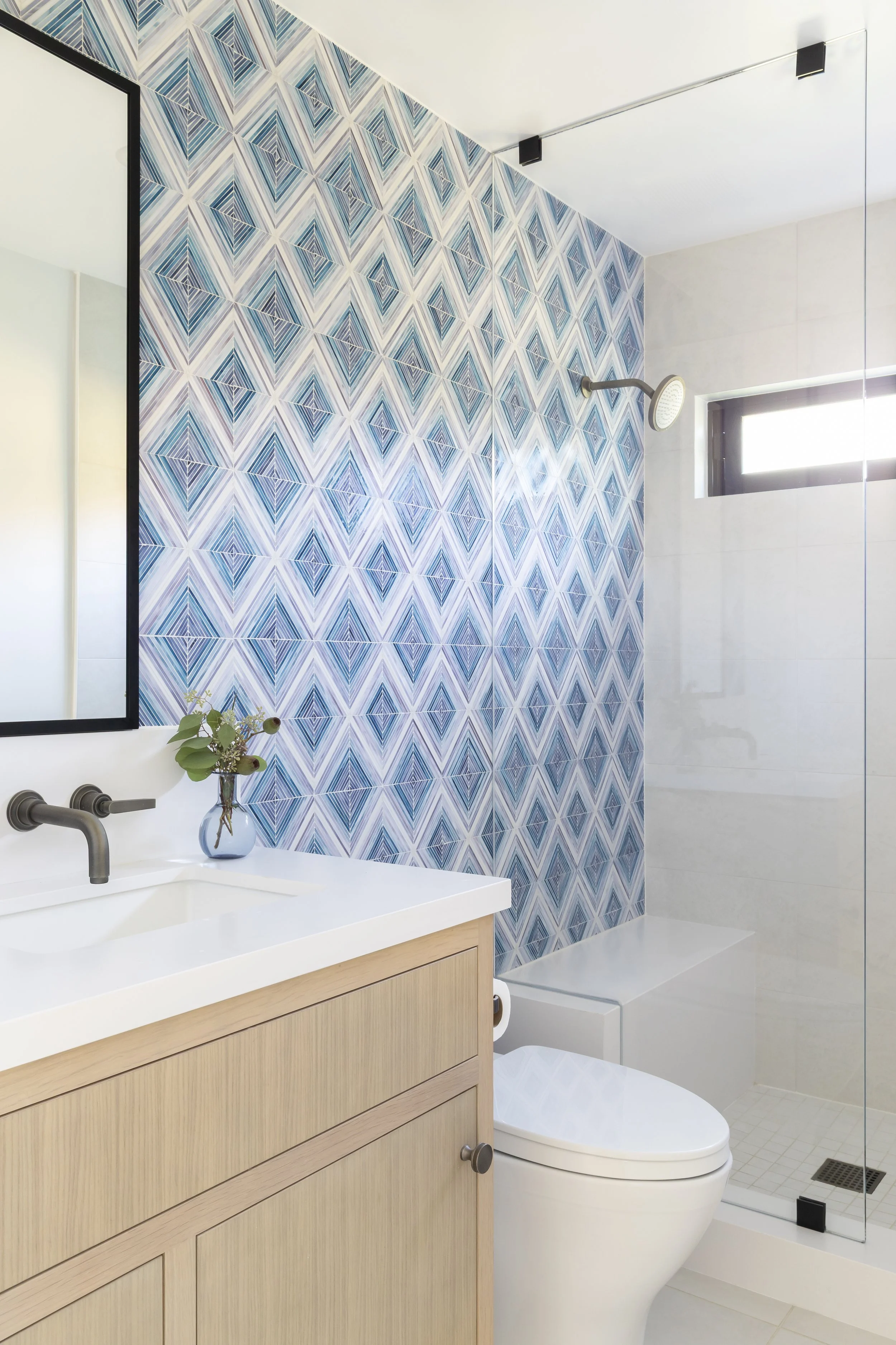 Solana Beach, CA bathroom design featuring a custom wood vanity, geometric blue tile shower, and fresh coastal-inspired finishes by Anne Flynn Designs.
