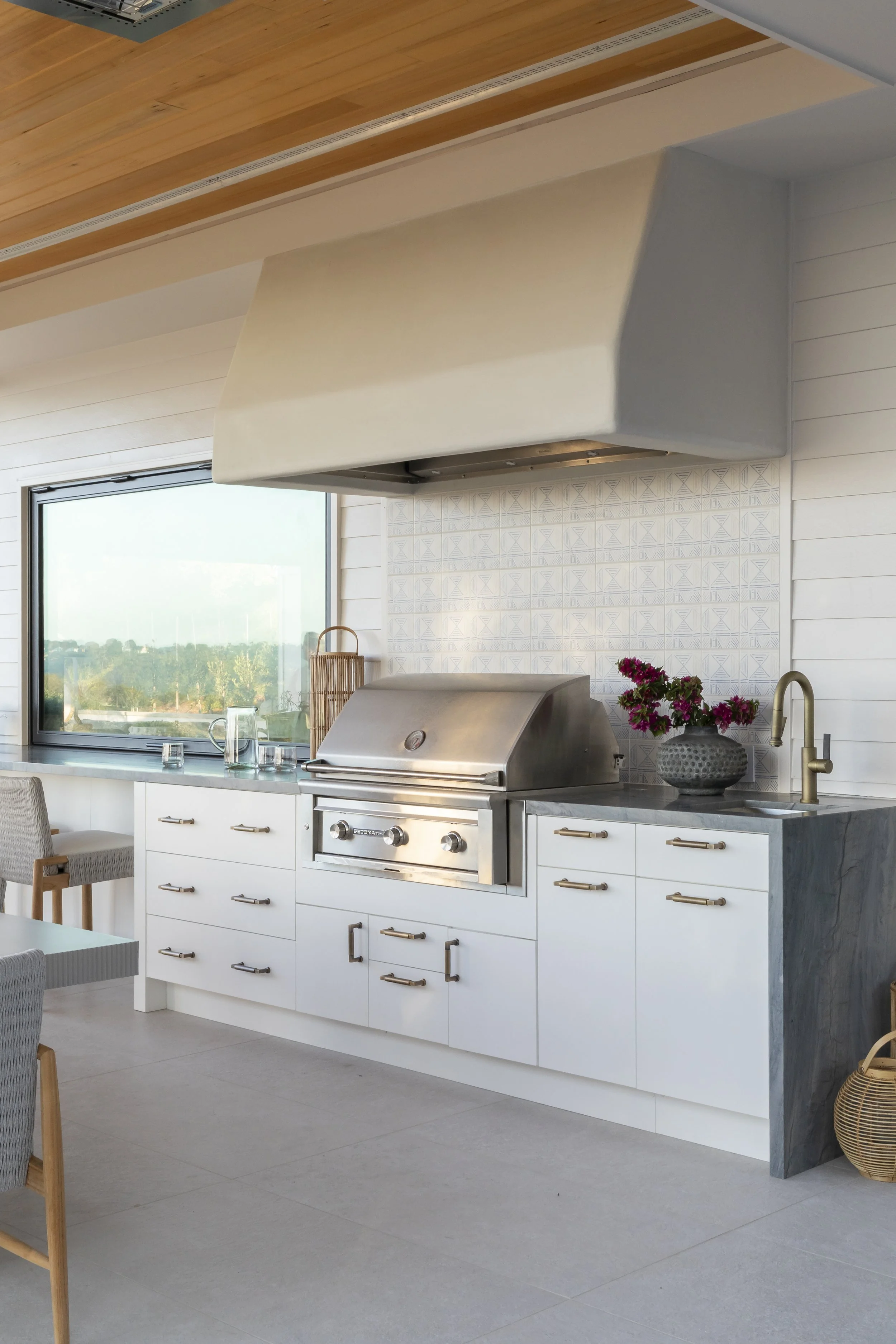 Solana Beach, CA outdoor kitchen design featuring a custom built-in grill, tailored cabinetry, and clean coastal finishes for elevated outdoor entertaining by Anne Flynn Designs.