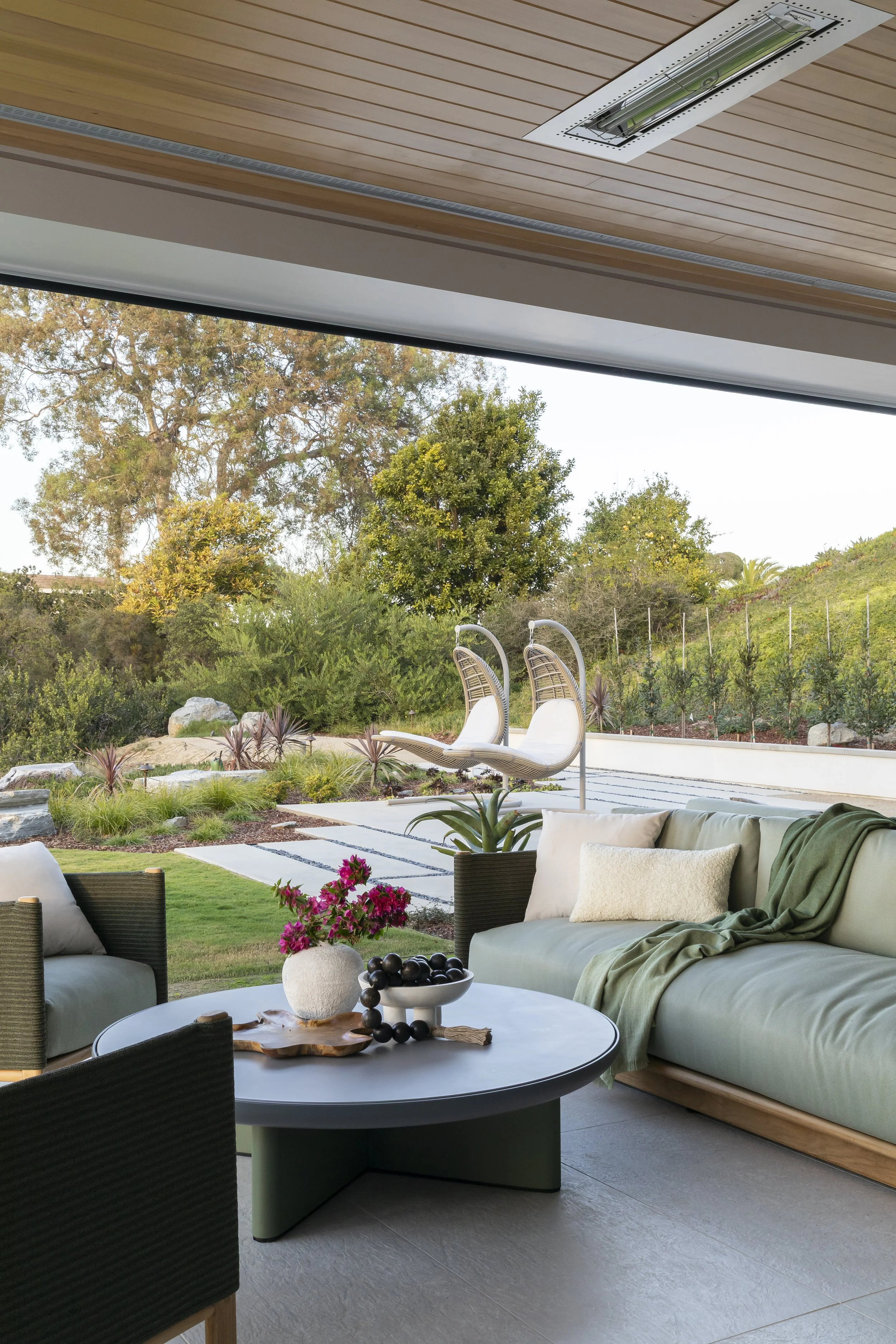 Solana Beach, CA outdoor living room design featuring a covered patio, custom outdoor seating, integrated heating, and a seamless indoor-outdoor connection photographed by Ryan Garvin
