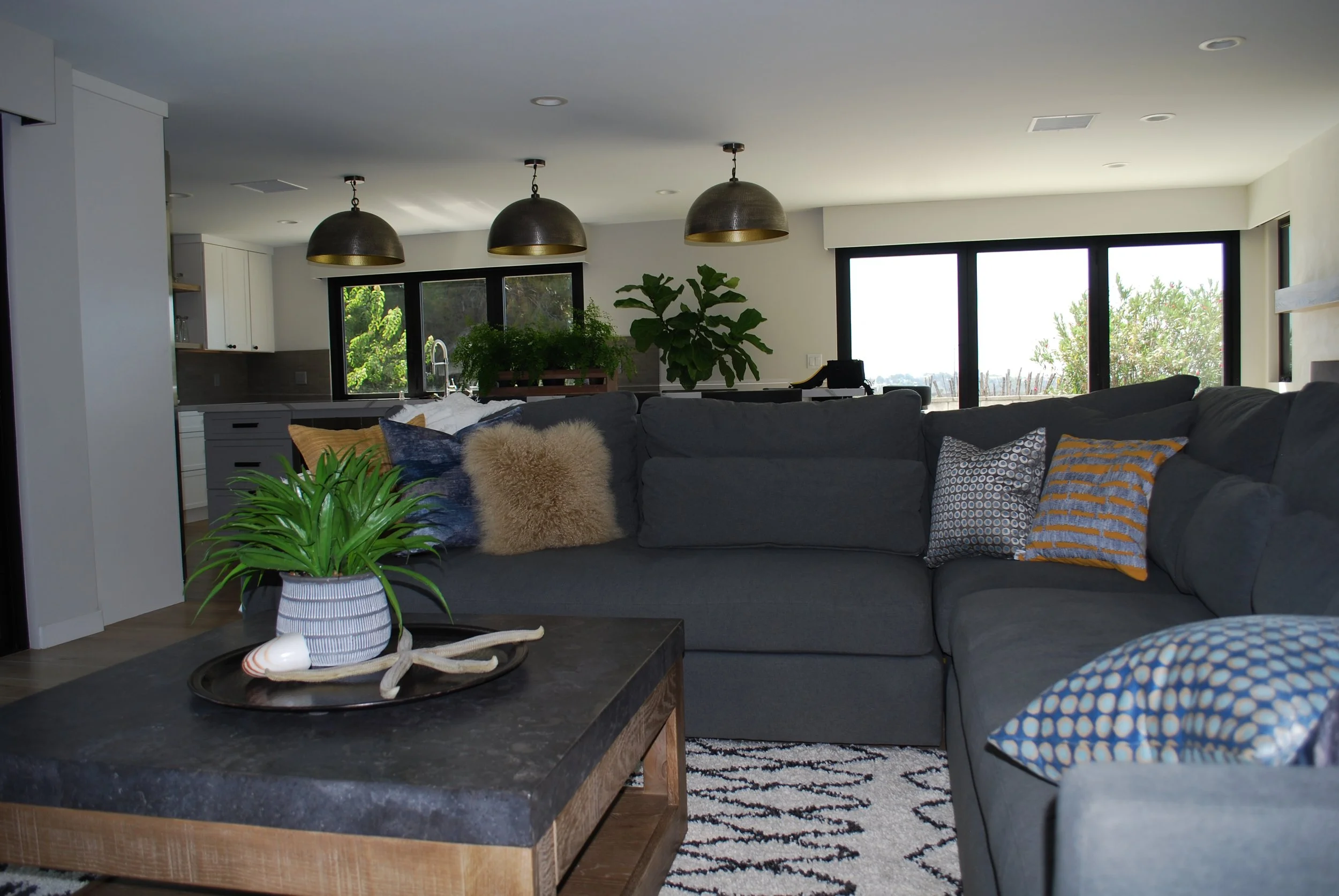 La Costa, CA living room design featuring an open-concept layout, custom sectional seating, layered textures, and warm contemporary styling by Anne Flynn Designs.
