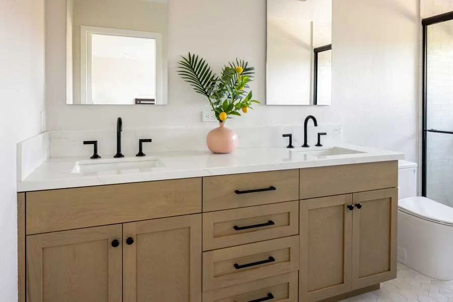 San Diego, CA bathroom design featuring a custom wood double vanity, clean white countertops, matte black fixtures, and fresh modern styling by Anne Flynn Designs.