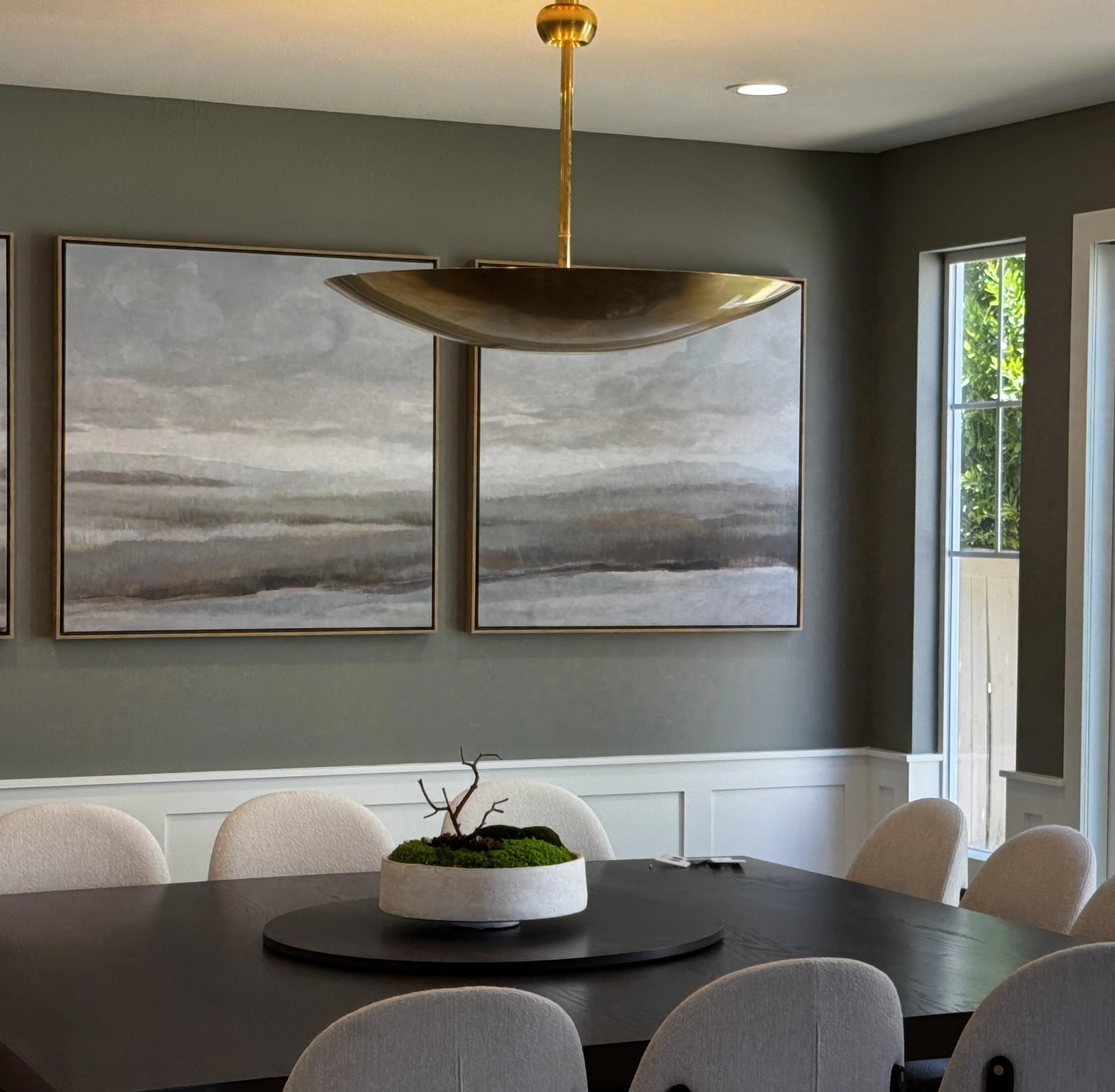 Carlsbad, CA dining room design featuring a sculptural brass pendant light, curated artwork, and soft transitional finishes for a refined, timeless aesthetic by Anne Flynn Designs.