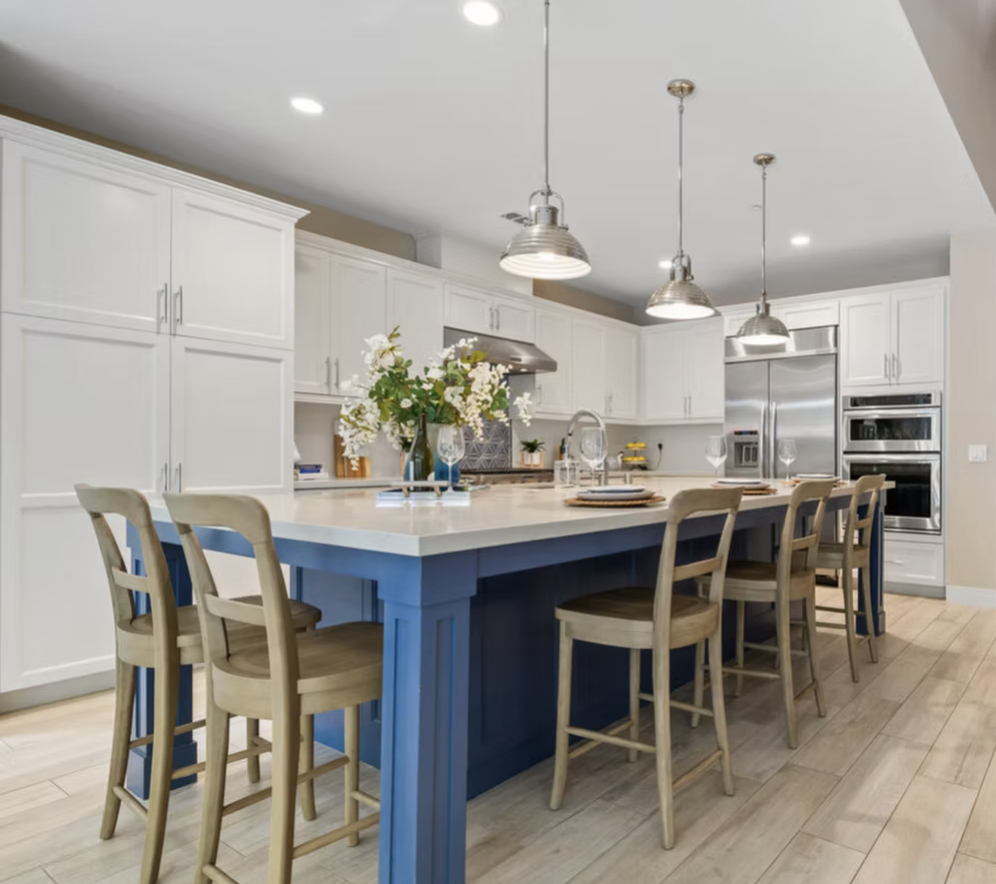 Encinitas, CA kitchen design featuring a bold blue island, classic white cabinetry, industrial-style pendant lighting, and fresh coastal detailing by Anne Flynn Designs.