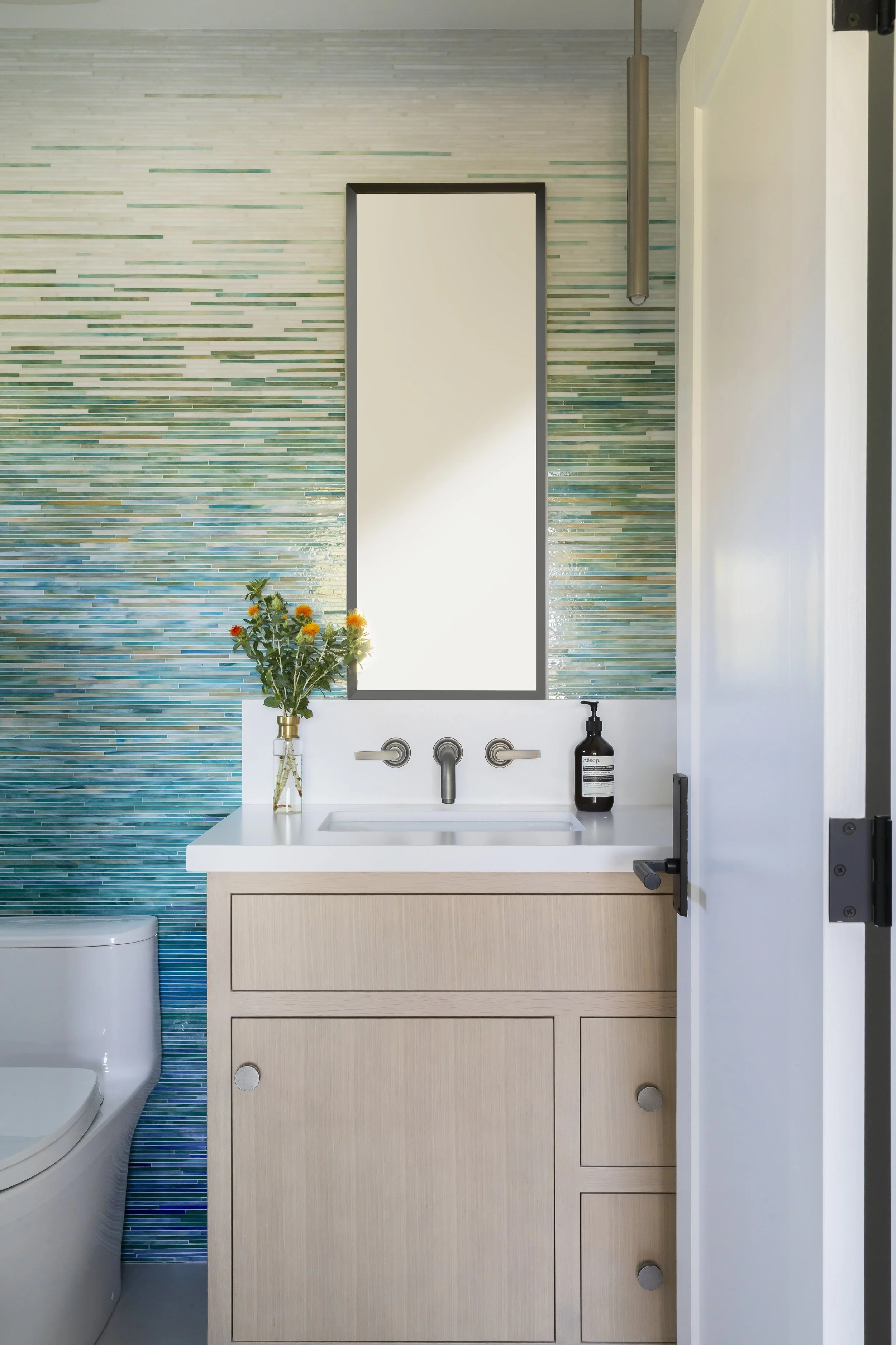 Solana Beach, CA bathroom design featuring a custom vanity, coastal-inspired tile backsplash, and clean modern finishes by Anne Flynn Designs.