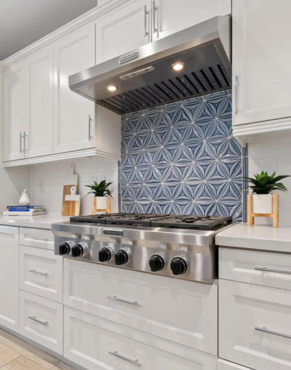 Encinitas, CA kitchen design featuring a bold blue island with integrated seating, classic white cabinetry, industrial-style pendant lighting, and bright coastal detailing by Anne Flynn Designs.
