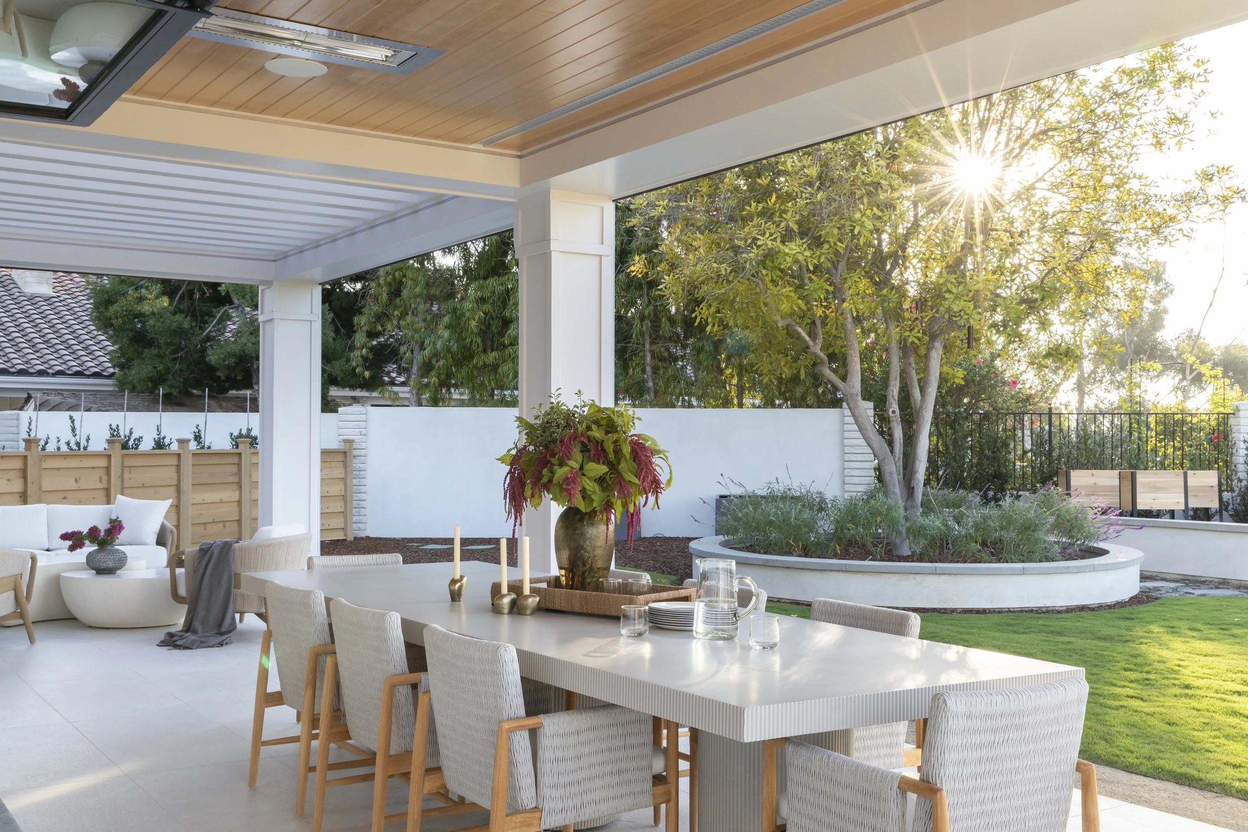 Solana Beach, CA outdoor dining design featuring a covered patio, custom outdoor dining table, and seamless indoor-outdoor living overlooking the lagoon by Anne Flynn Designs, photographed by Ryan Garvin.