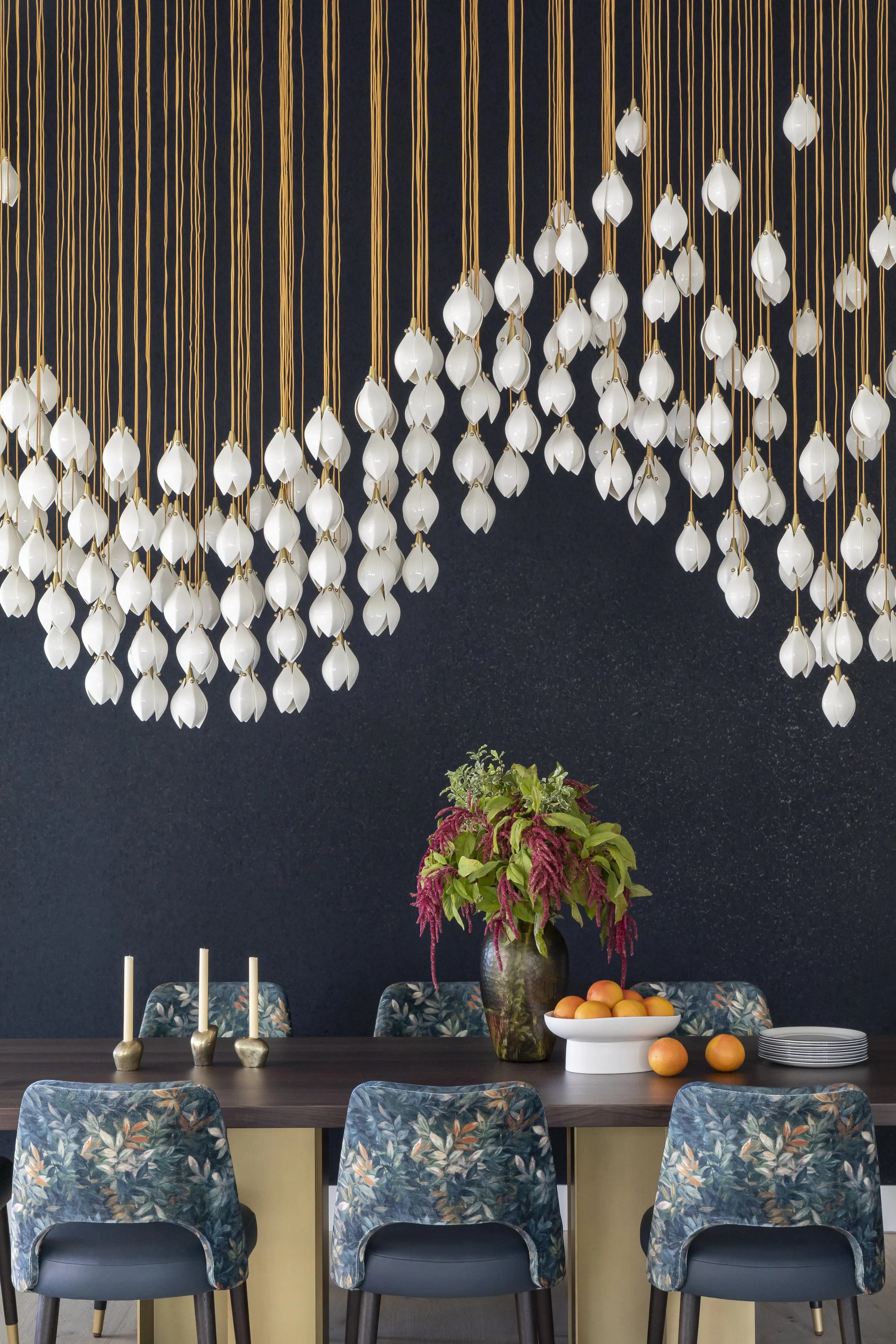 Solana Beach, CA dining room design featuring a sculptural cascading pendant chandelier, moody accent wall, and custom dining furnishings by Anne Flynn Designs, photographed by Ryan Garvin.