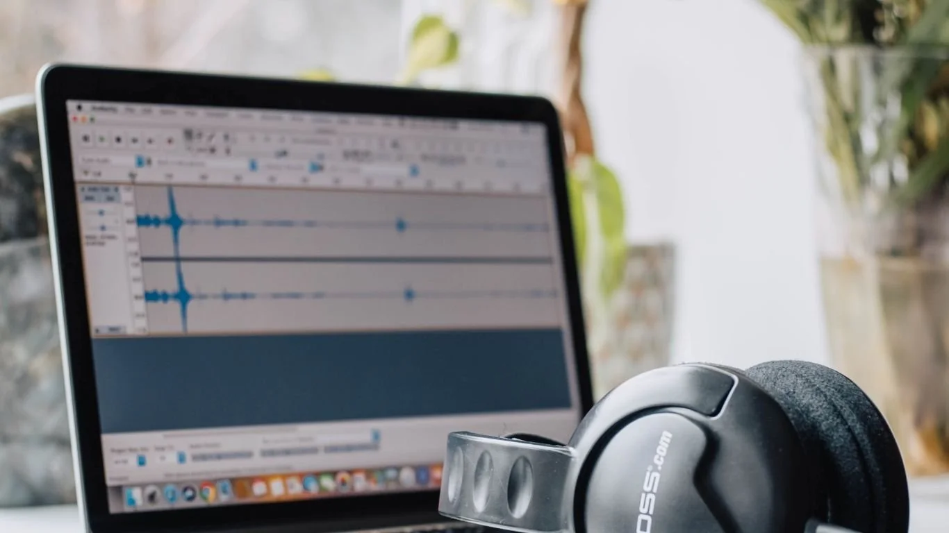 Audio-opname met zichtbare geluids­golven en koptelefoon, gebruikt voor handmatige transcriptie en controle van AI-transcripties.