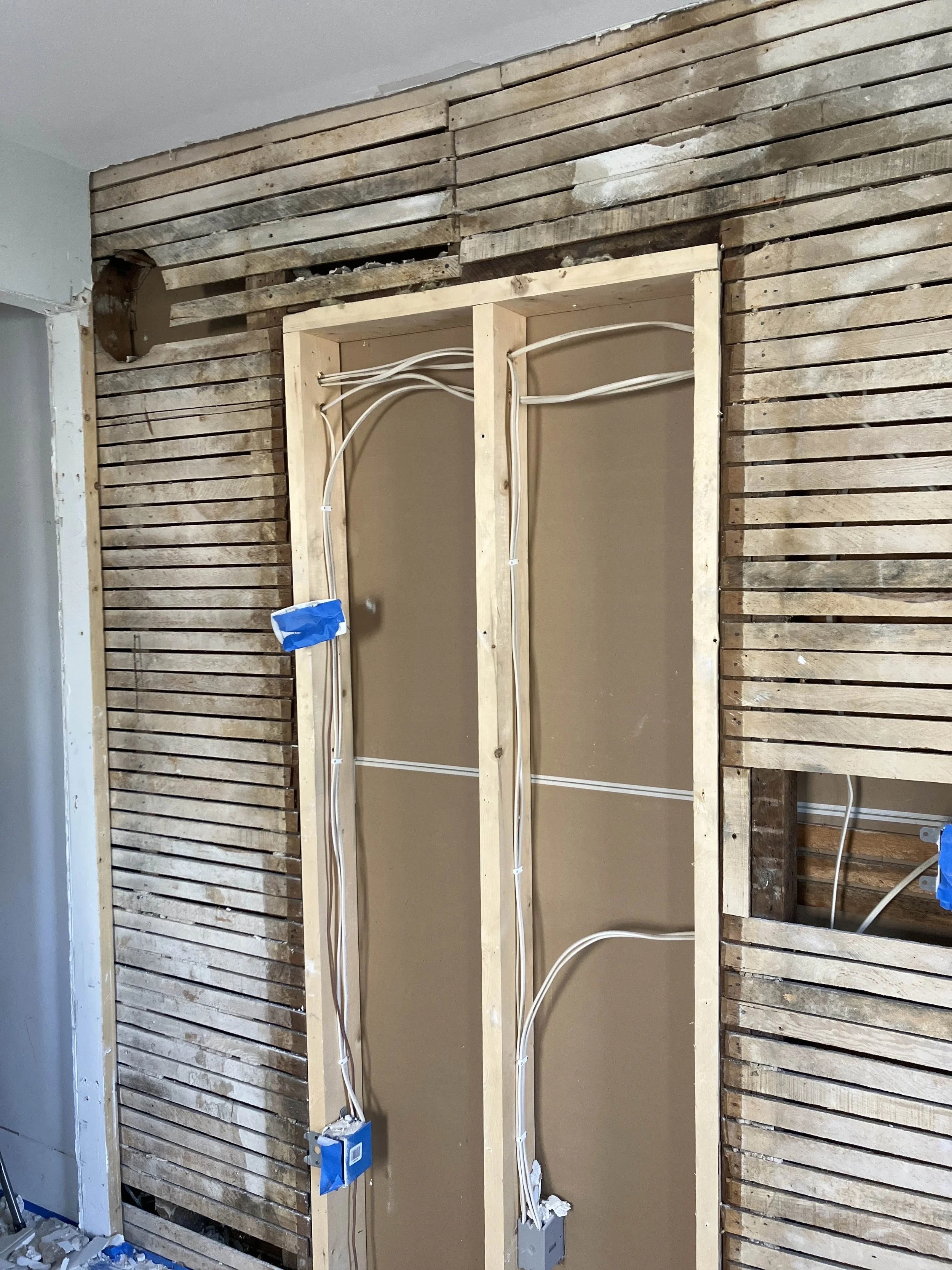 Interior wall under renovation with exposed wooden lath and wiring