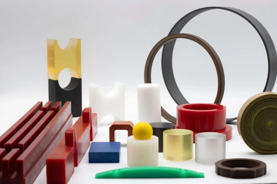 A collection of various colorful rubber bands, including red, yellow, green, black, white, and brown, arranged on a white surface.