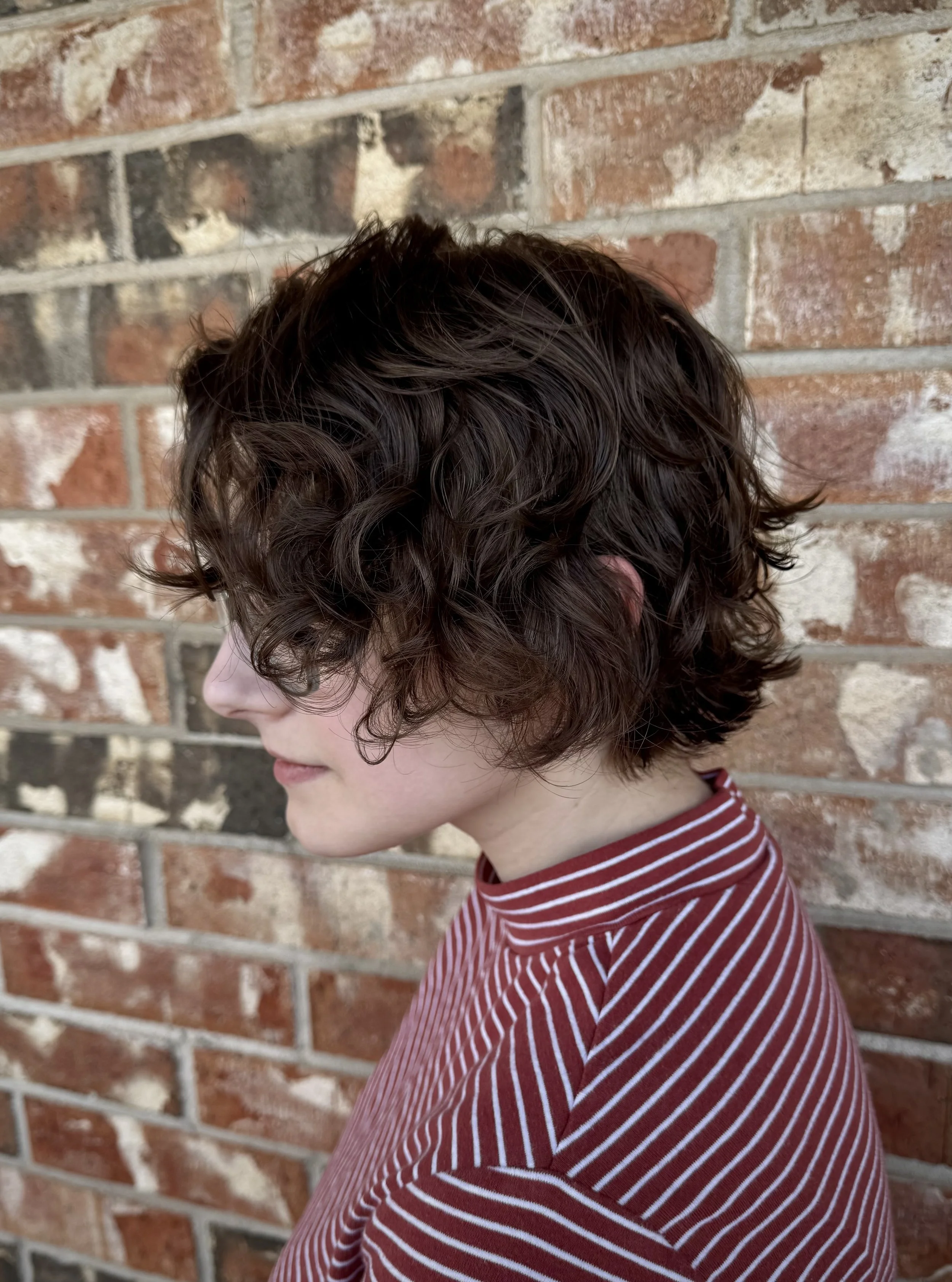 person with short curly bixie, a cross between a bob and a pixie haircut