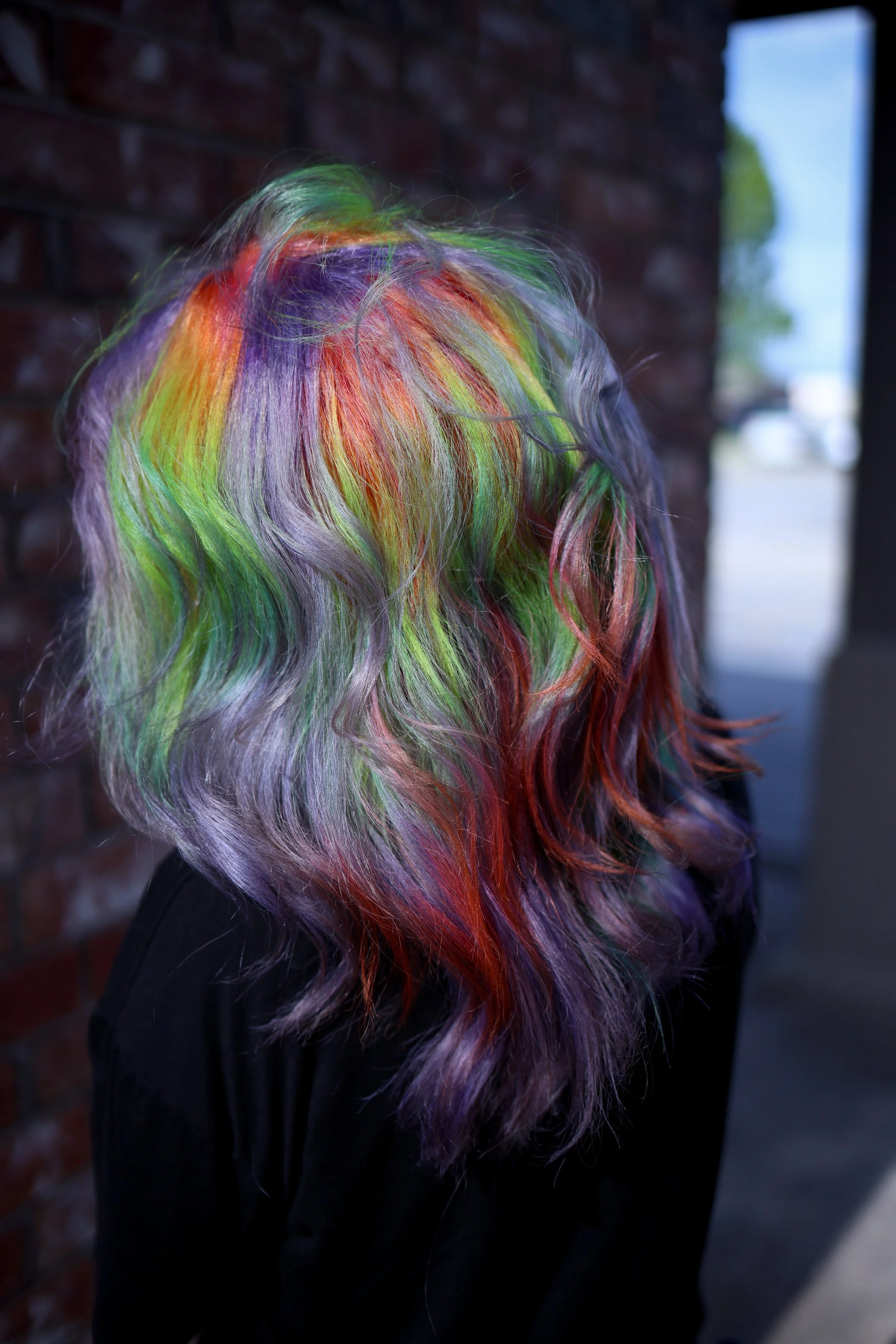 person with medium length smoky pastel purple hair with rainbow prism highlights throughout