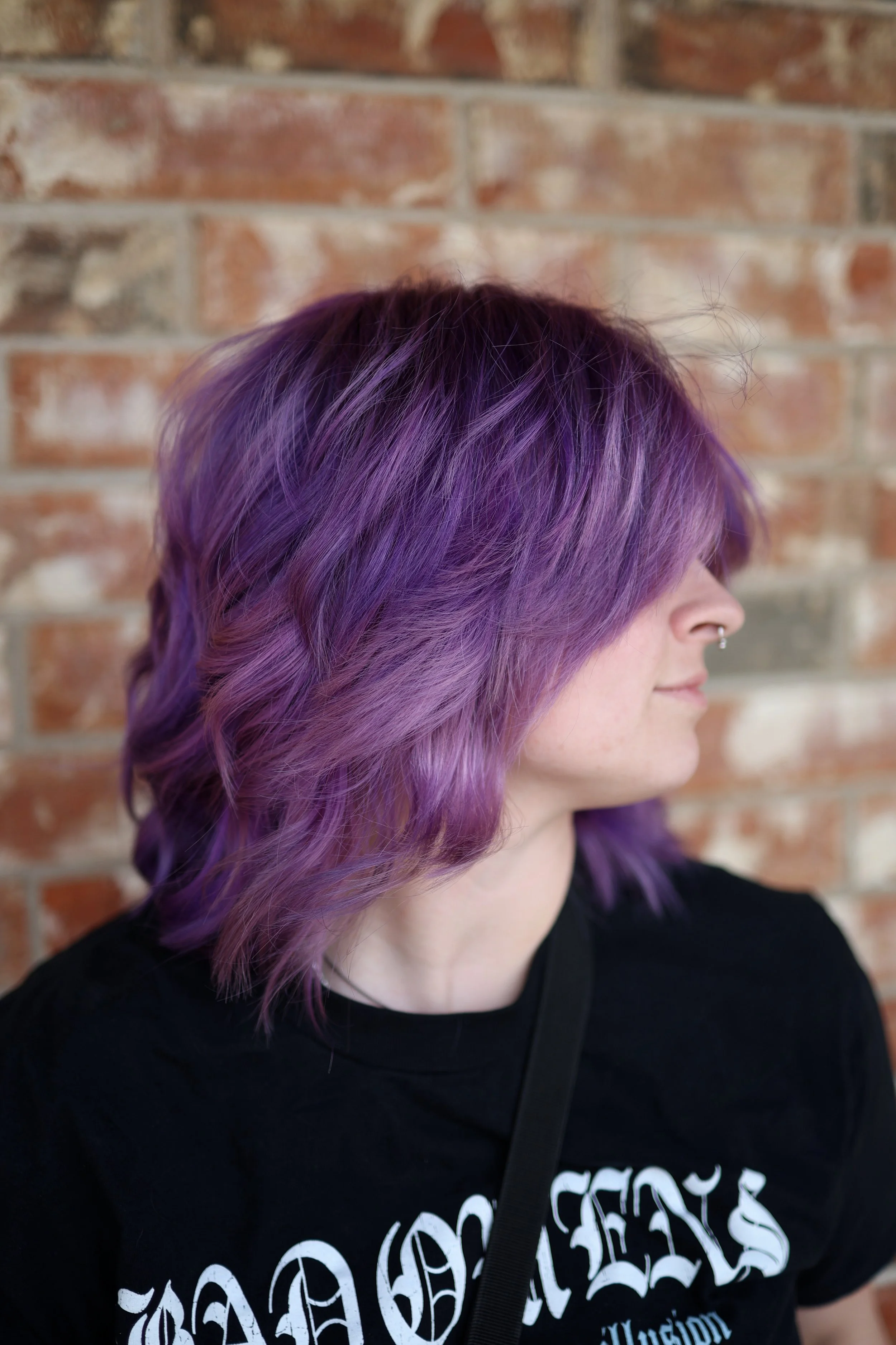 person with shoulder length purple hair and a wolfcut