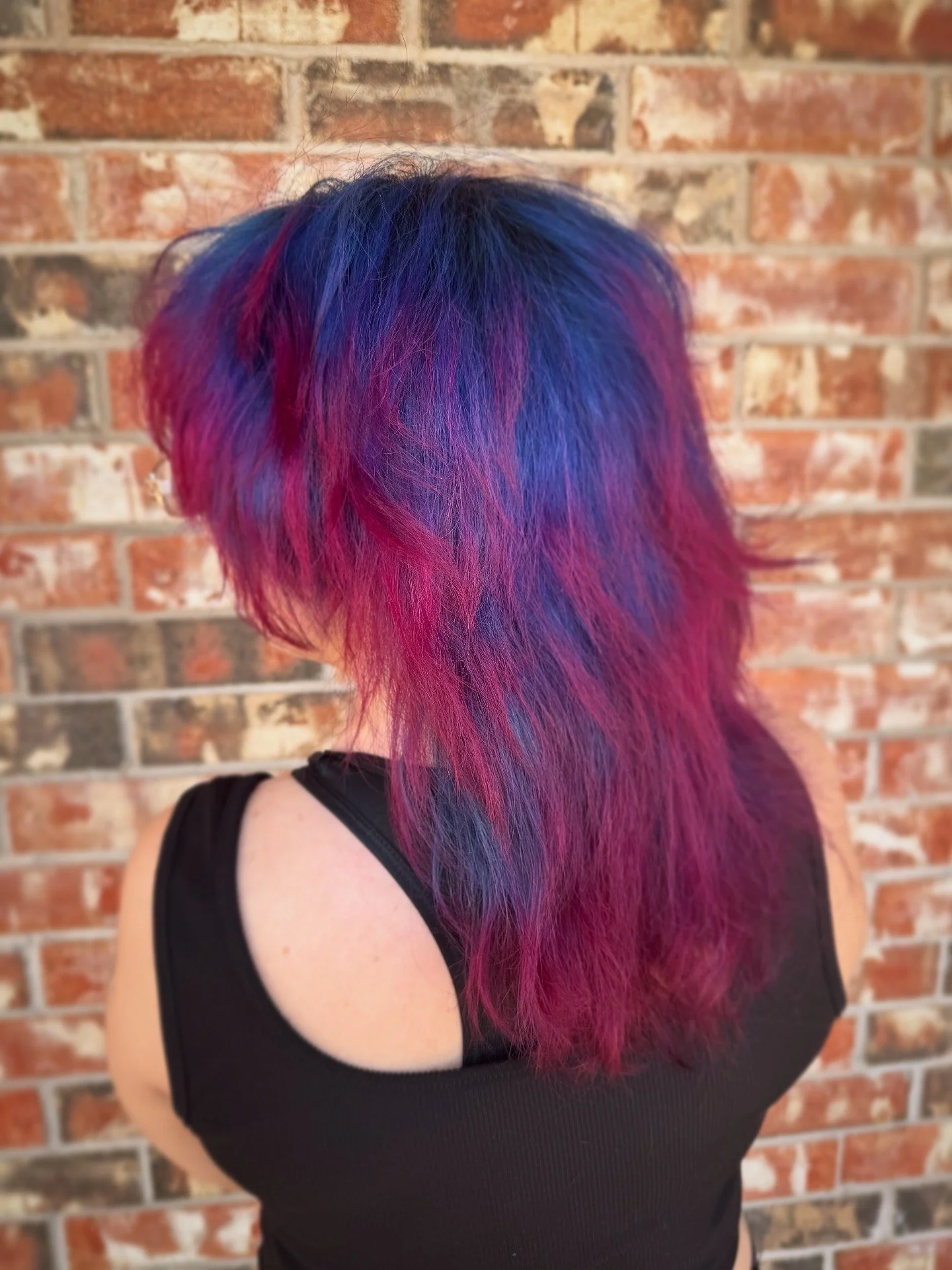 person with spider-man inspired hair, dark blue with red tips