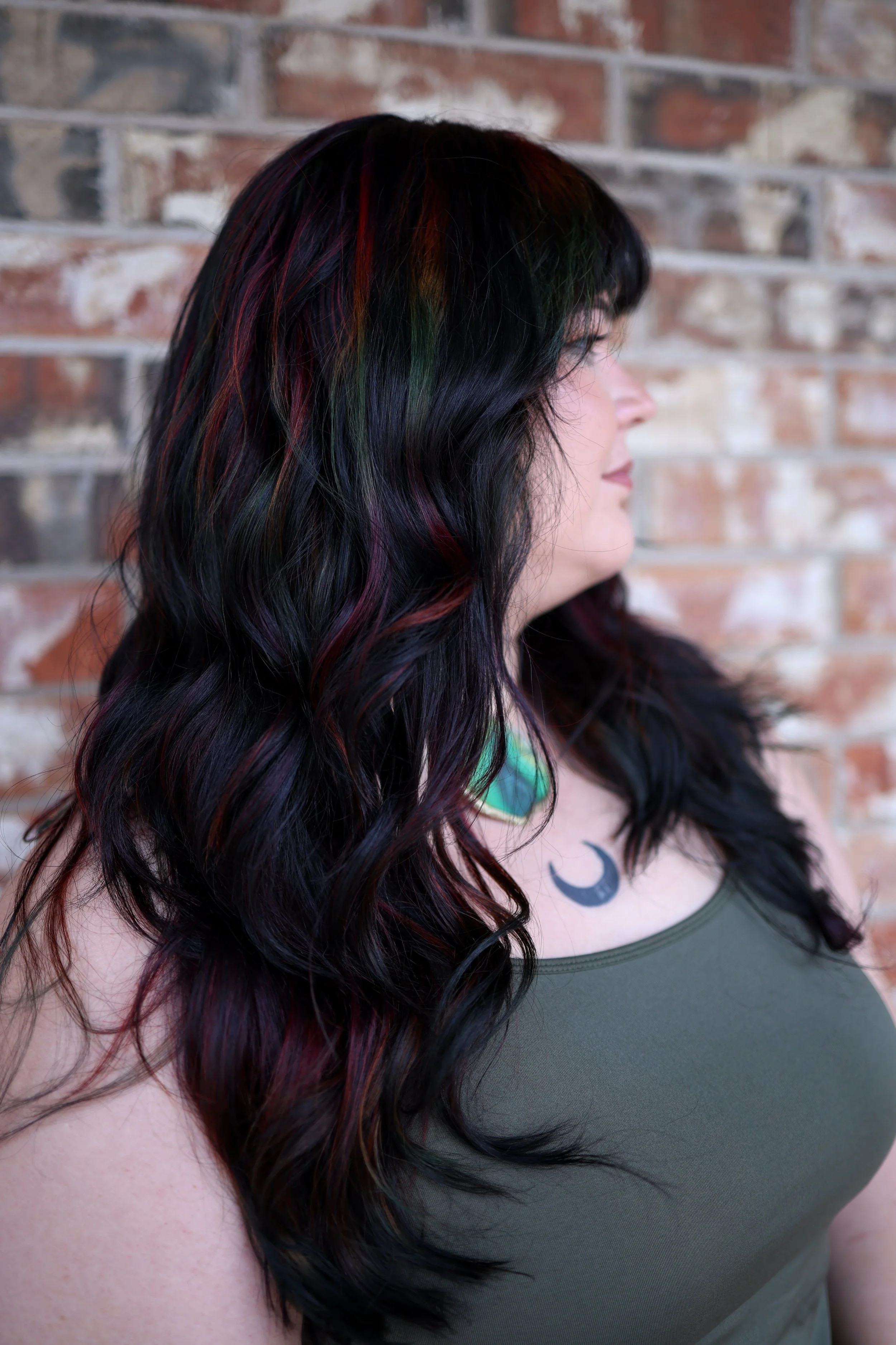 woman with long black hair and hidden dark moody prism oil slick highlights