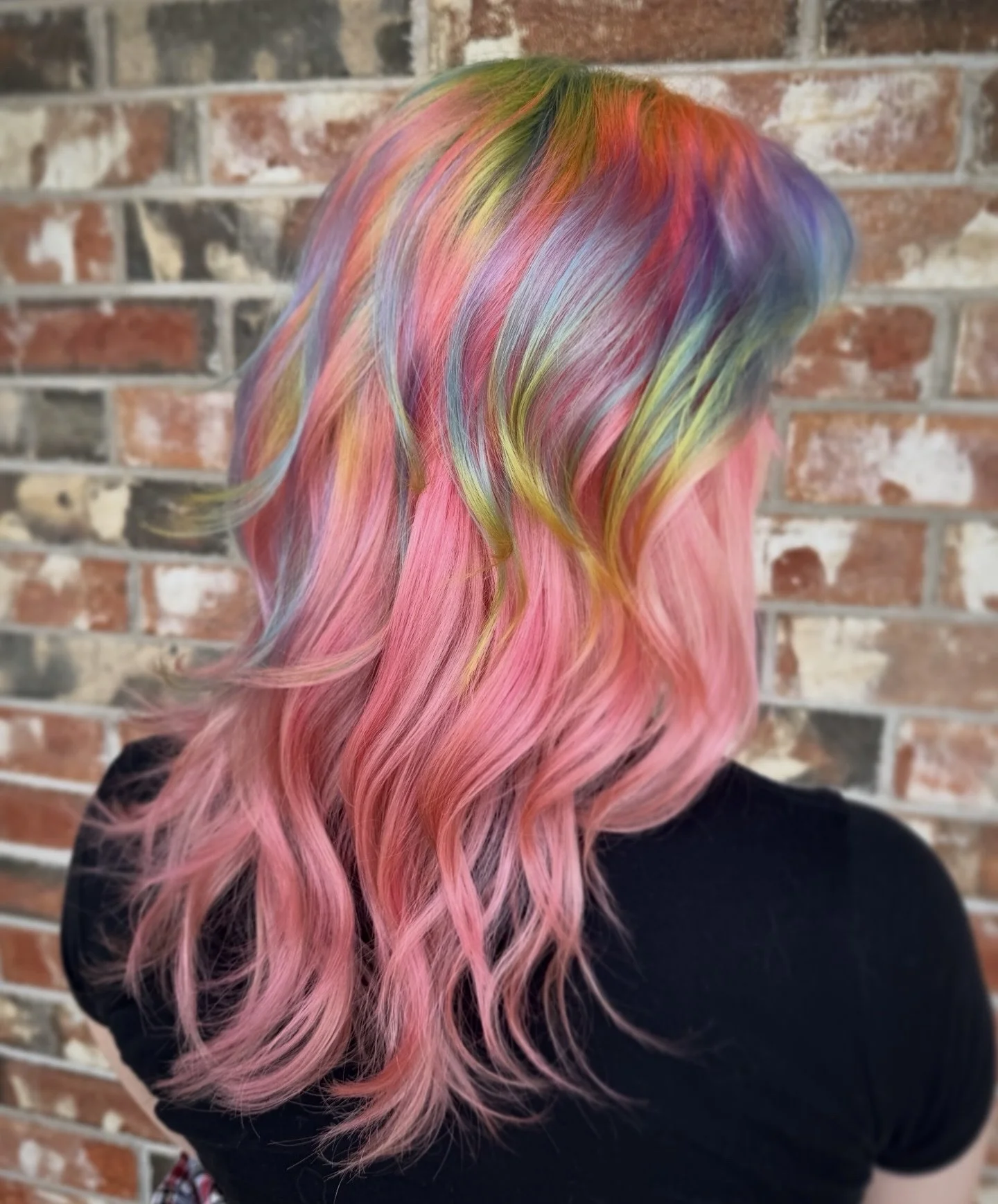 girl with medium length bubblegum pink hair with an overlay of prism rainbow hair on top