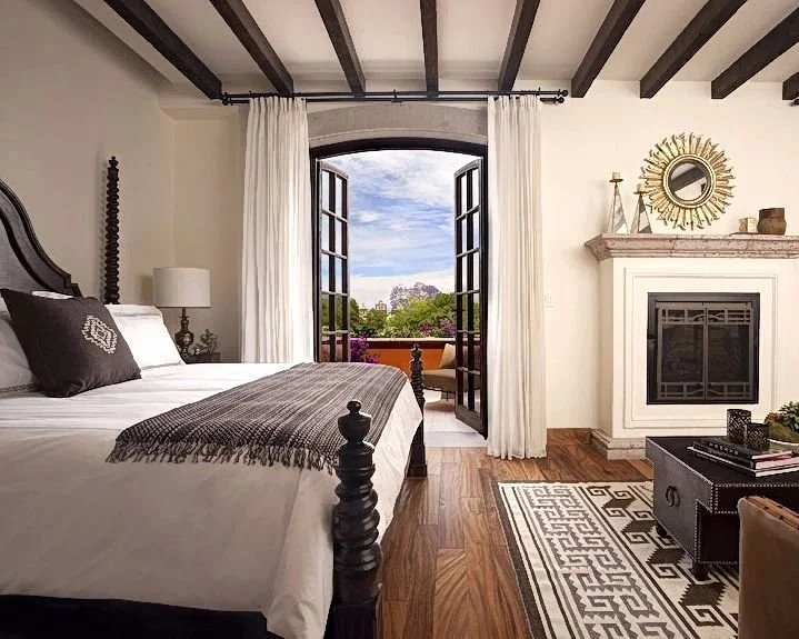 Room with bed fire place and open window at the Rosewood hotel in San Miguel de Allende Mexico where we to stem cell therapy.