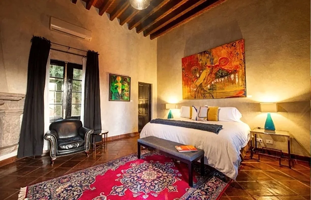 room with bed, wood ceiling and painting in hotel casa feliciana San Miguel de Allende where we do stem cell therapy.