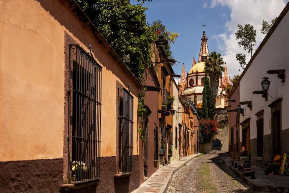 colorful colonial street in San Miguel de Allende with historic architecture and church