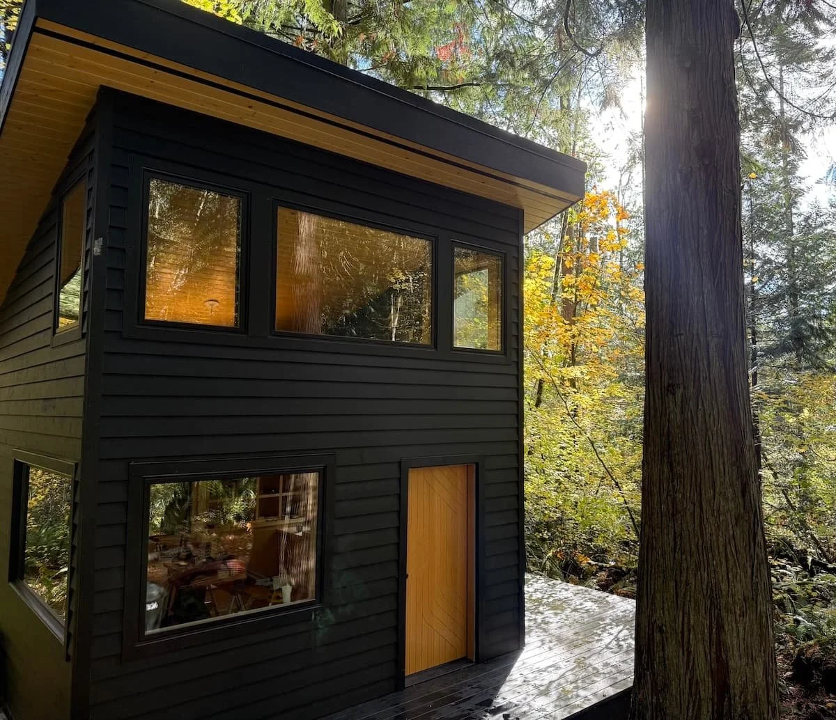 Black Cabin with CNC white oak front door and black cedar deck in the sun