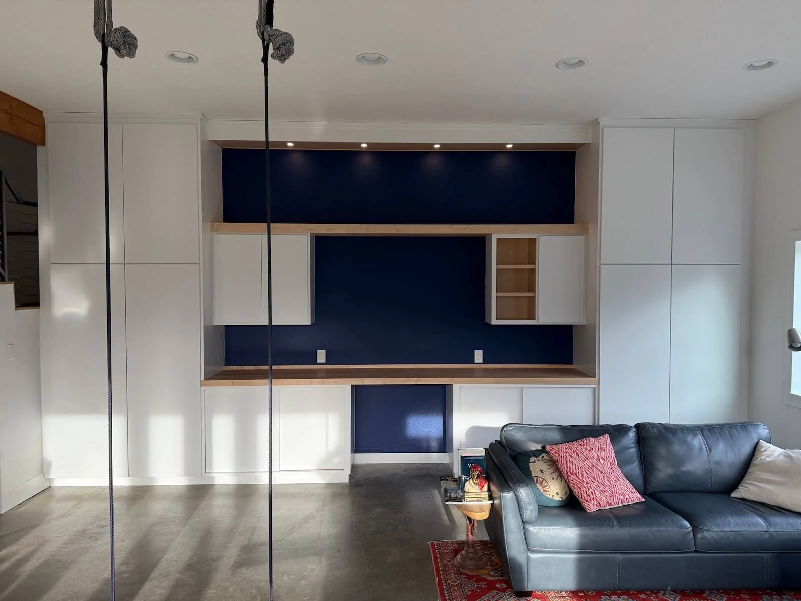 Remodeled room with built-in cabinetry with shelving and lighting