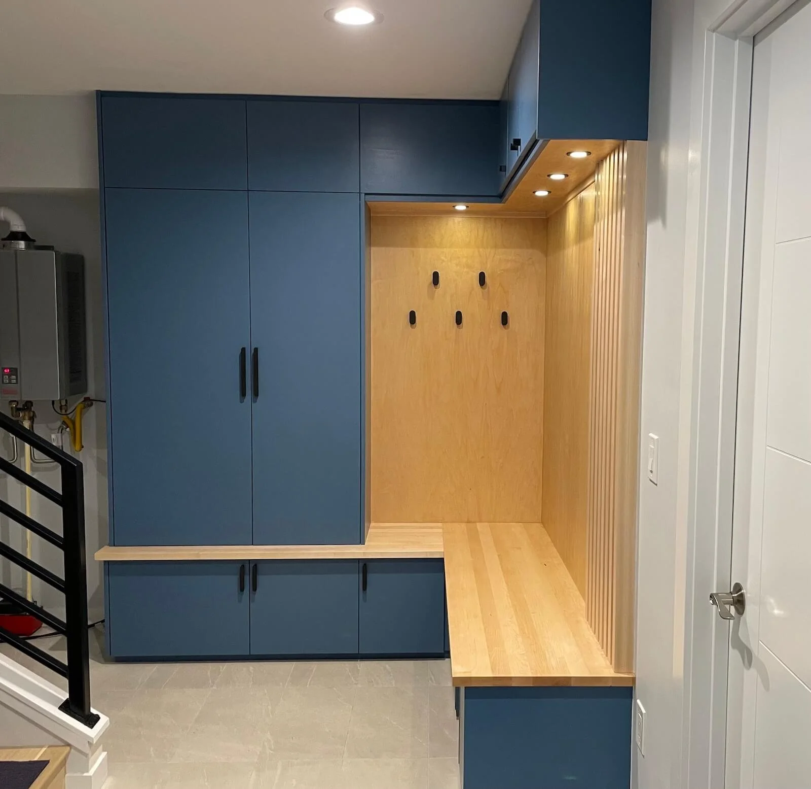 Custom built-in mudroom with storage for shoes and coats, bench seat and built-in lighting