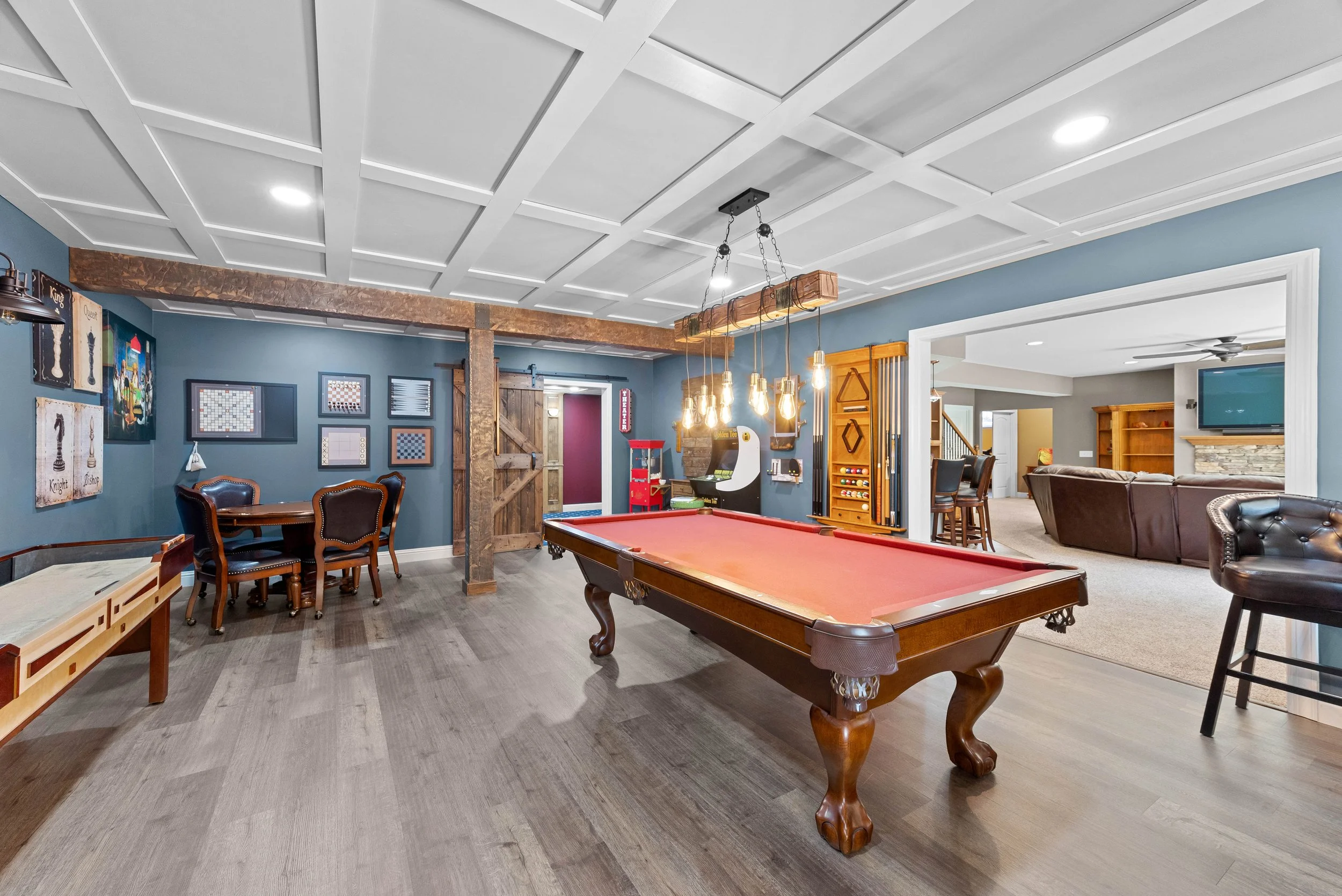 Game room with pool table, seating area, and artwork on blue walls.