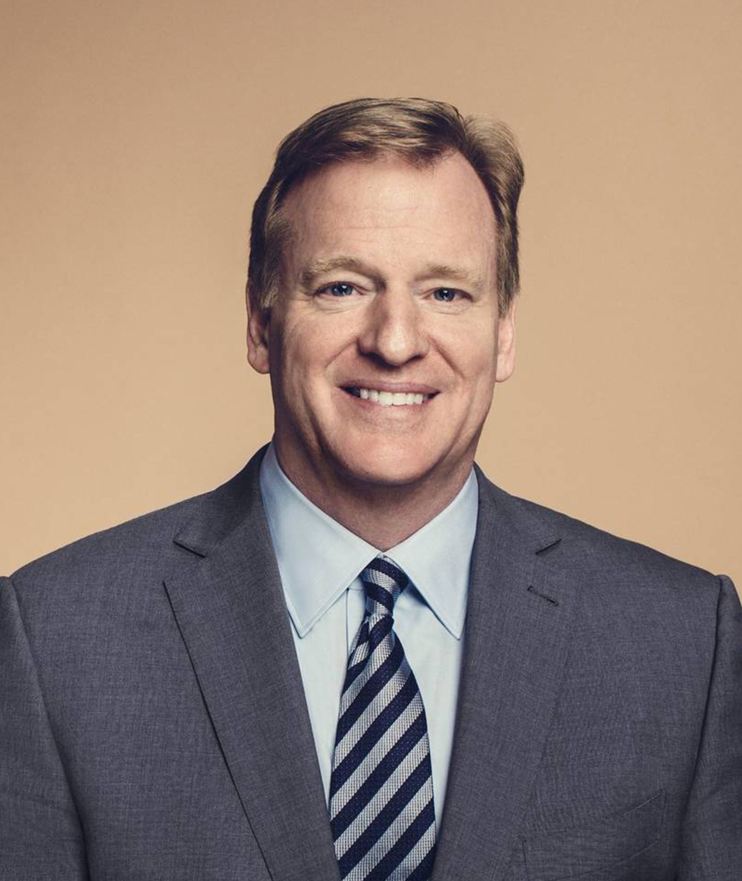 A professional portrait of a middle-aged man in a suit and tie smiling at the camera.