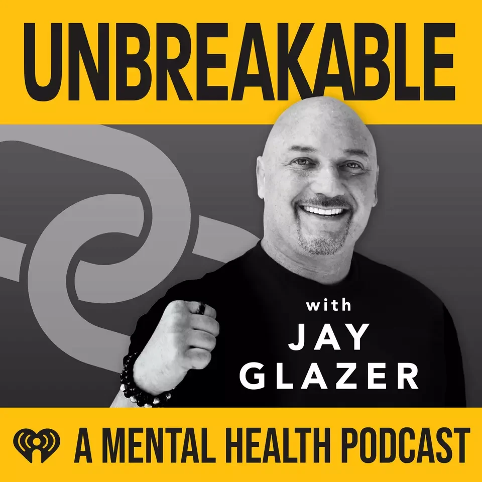 Podcast cover image for 'Unbreakable with Jay Glazer', a mental health podcast, featuring a smiling man with a shaved head, a goatee, wearing a black shirt, clenched fist, against a yellow and gray background with bold black and white text and a podcast logo.