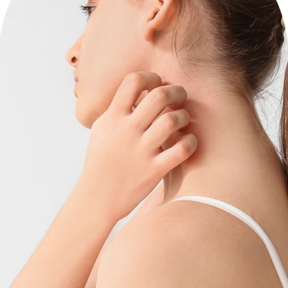 A woman touching her left earlobe with her hand, shown in profile with her hair tied back, wearing a white strap top.