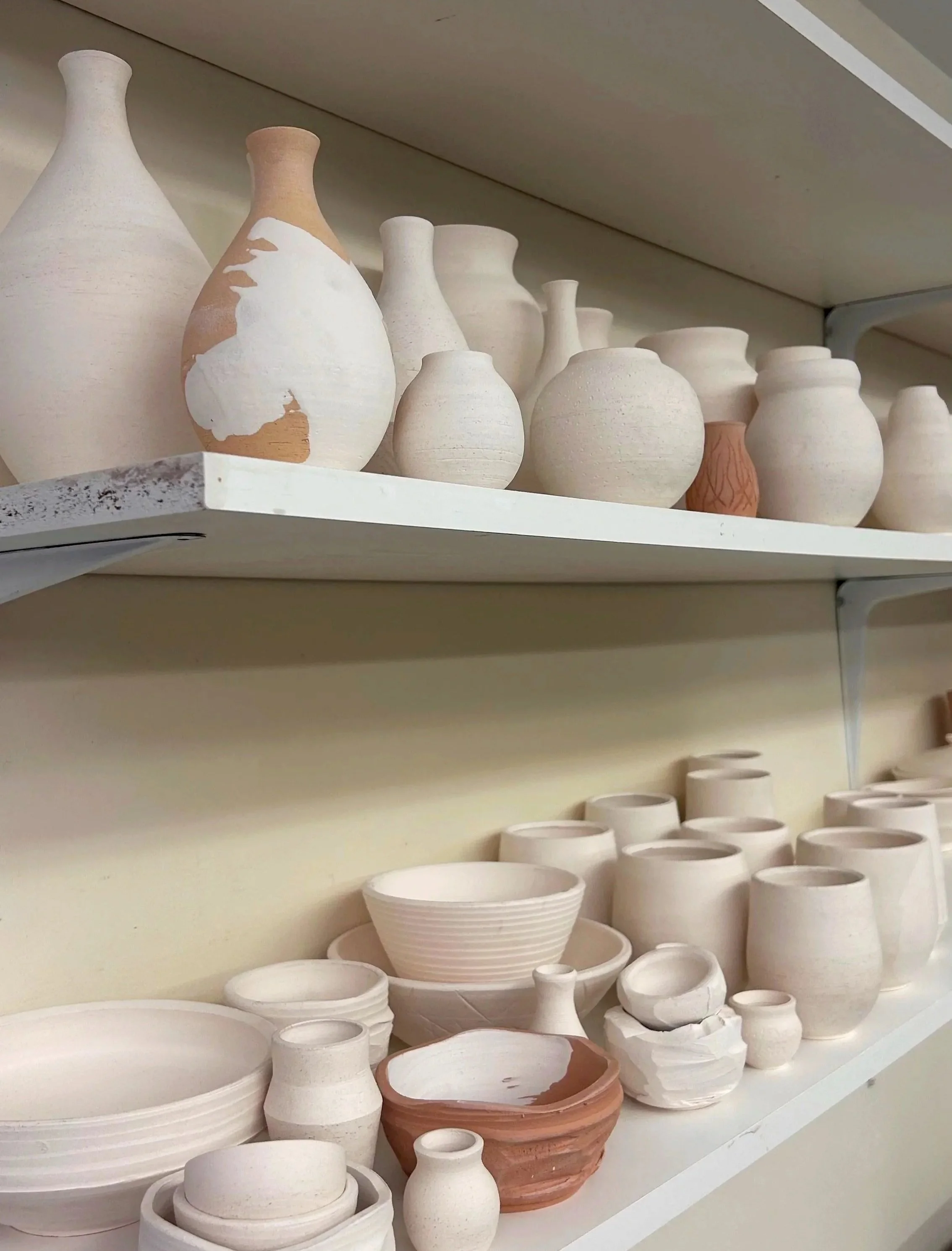 Shelves of bisqueware pottery.
