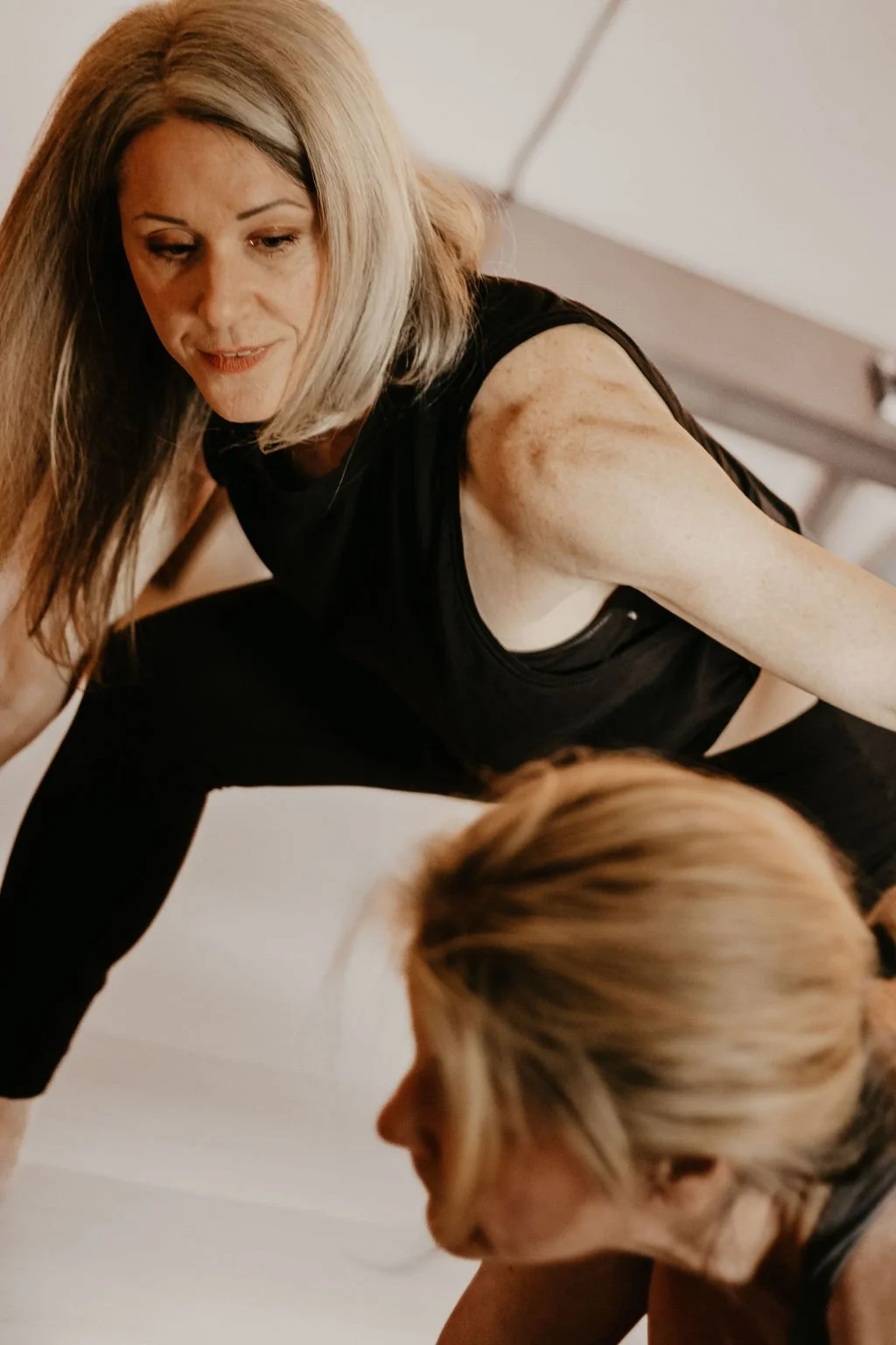 Woman assisting with a yoga pose.