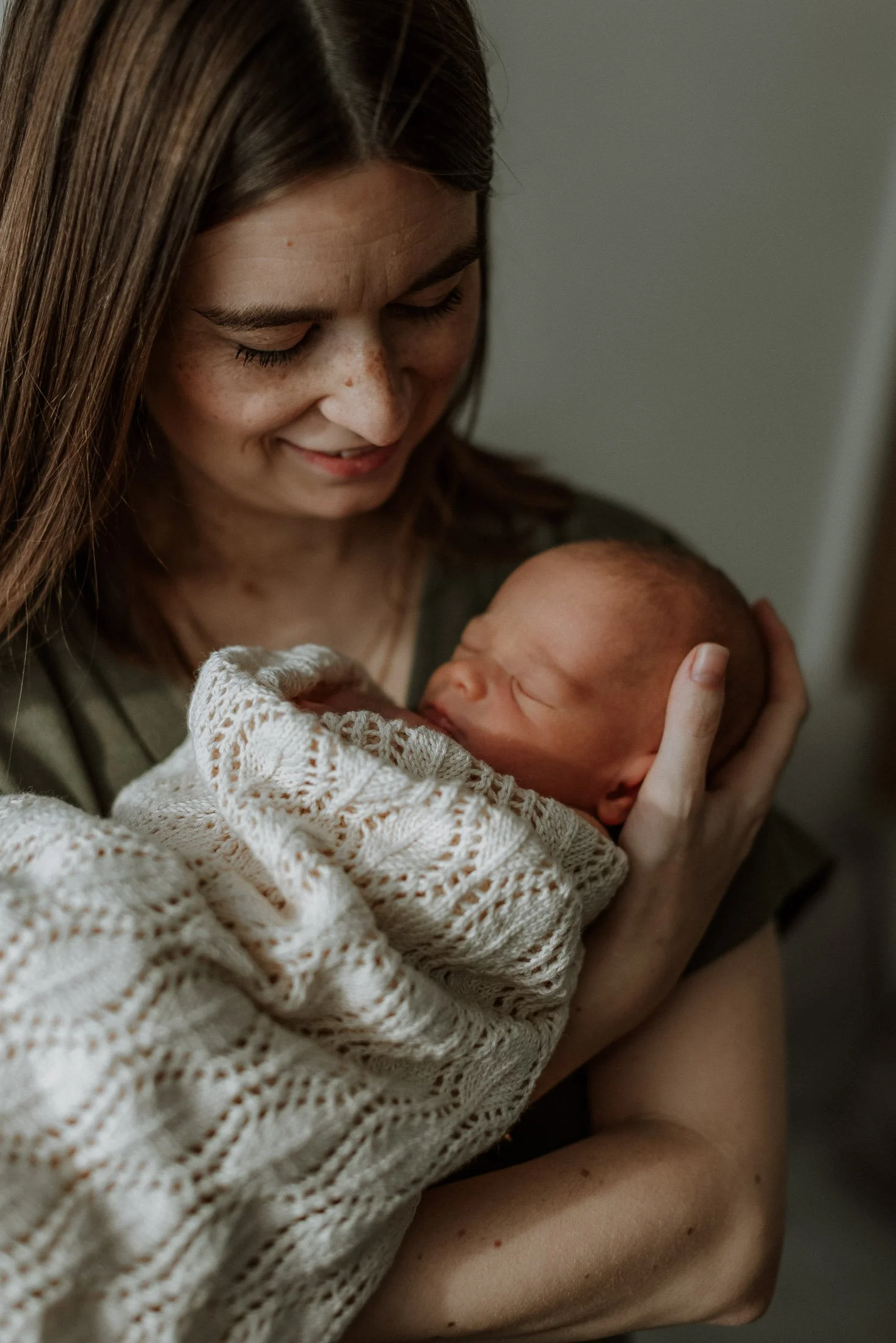 In home newborn shoot, mother holding newborn newborn baby