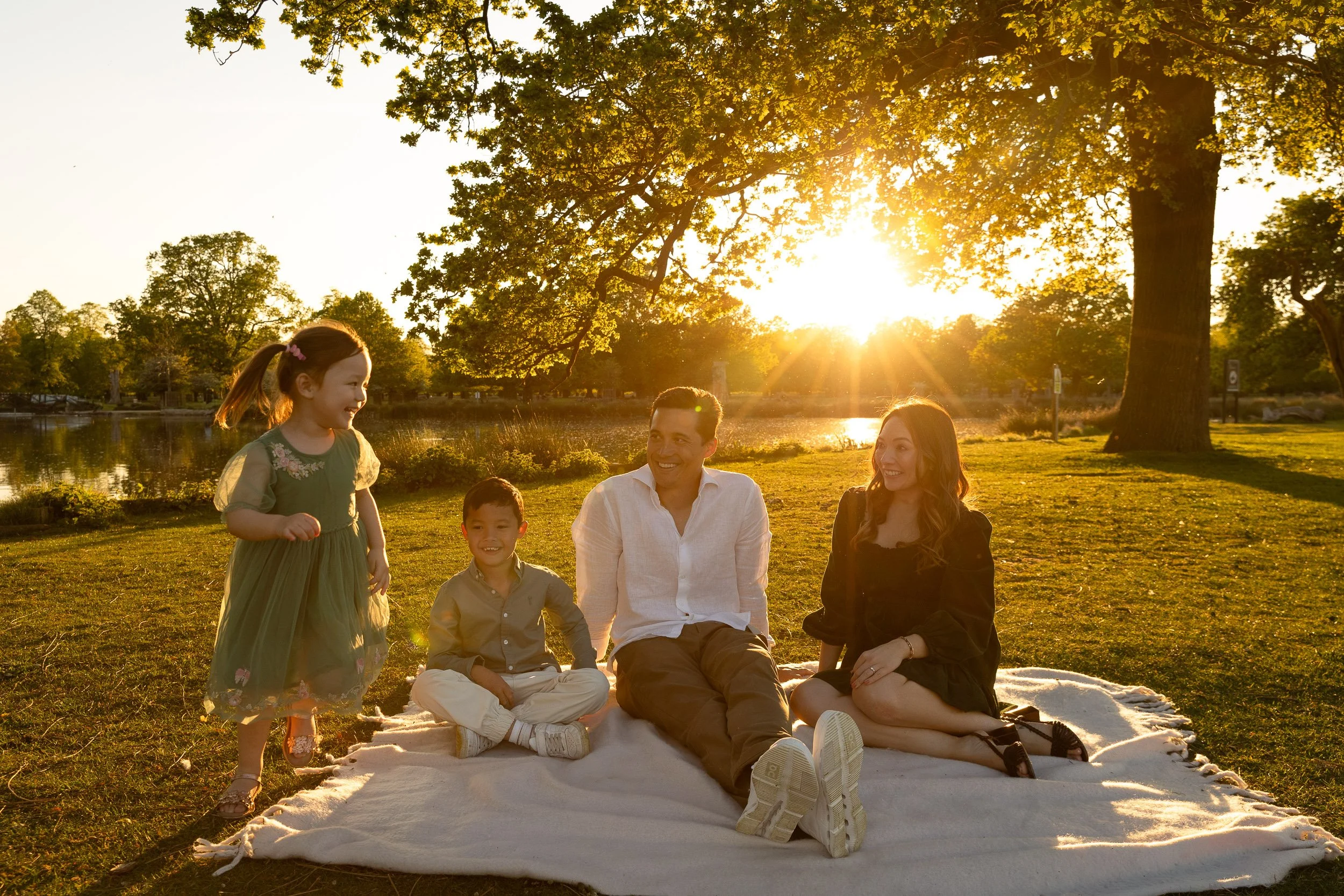Family photo with two parents and little girl on outdoor shoot in Surrey park in autumn