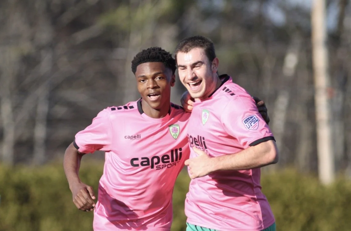 Demunga Alfani and Oliver Nigro embrace after the latter opened the scoring for the Clover.