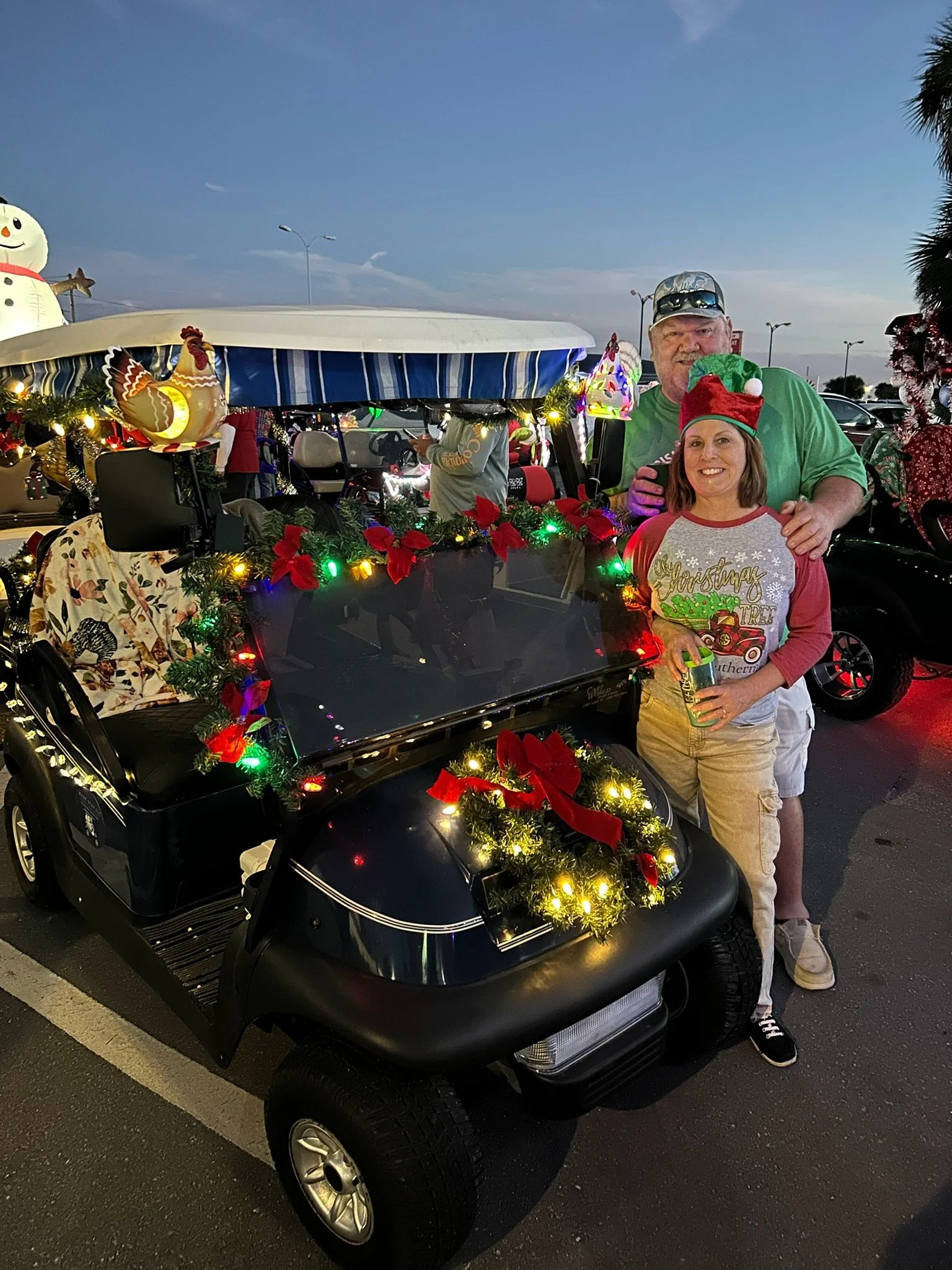 Owners Les and Stephanie Wade with Golf Cart decorated for Christmas Golf Cart parade in Crystal River, Florida