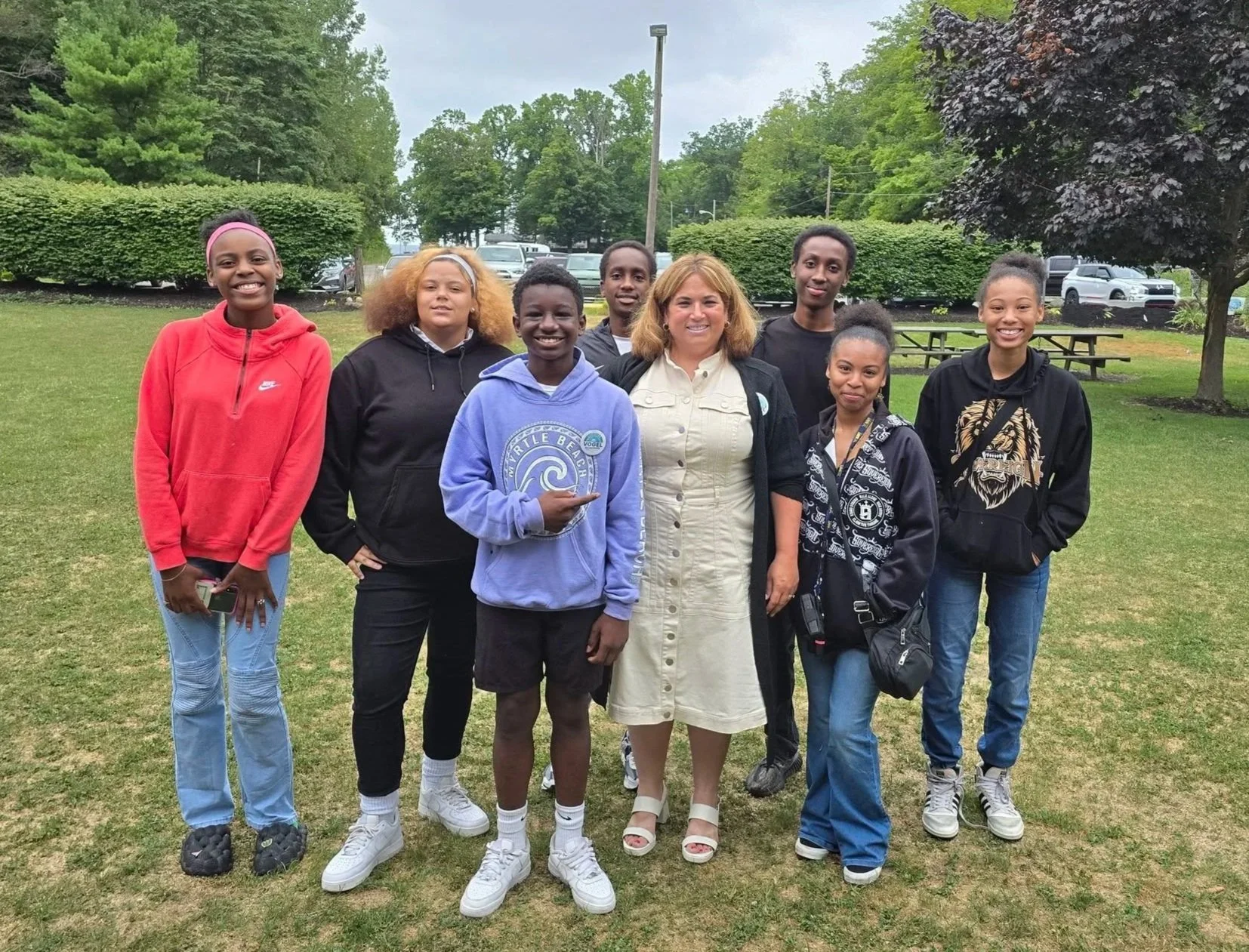 Group of young teenagers with County Executive Christina Vogel in the middle, all smiling.